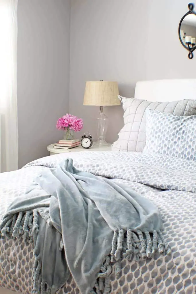 white upholstered headboard and blue west elm bedding 