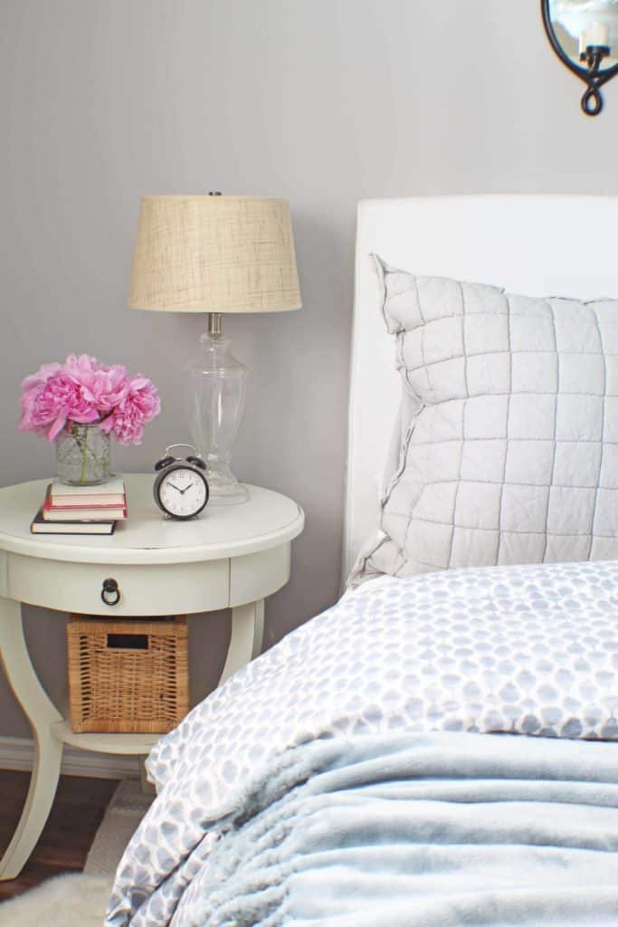 white upholstered headboard and blue west elm bedding 