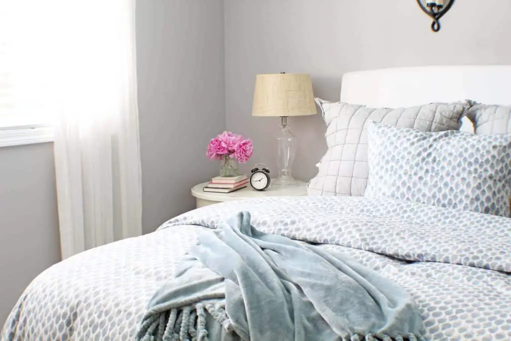 white upholstered headboard and blue west elm bedding 