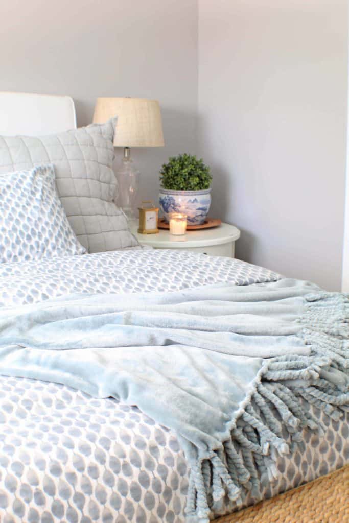 white upholstered headboard and blue west elm bedding 