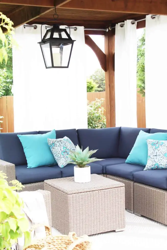 Summer is just around the corner, which means longer days and more outdoor time. Are you stuck on where to start with your outdoor space? Try these 5 simple patio makeover ideas.  #summerpatio #outdoorspace #outdoorlanterns #pergola #wickersectional #outdoorcurtains #outdoorrug #summerentertaining #outdoorlivingroom #bluedecor #aquadecor #backpatio #backyard #backdeck #smallyard