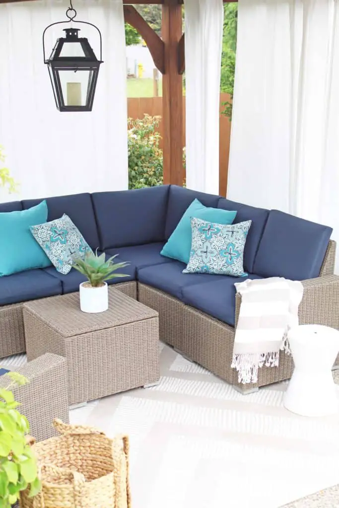 Summer is just around the corner, which means longer days and more outdoor time. Are you stuck on where to start with your outdoor space? Try these 5 simple patio makeover ideas.  #summerpatio #outdoorspace #outdoorlanterns #pergola #wickersectional #outdoorcurtains #outdoorrug #summerentertaining #outdoorlivingroom #bluedecor #aquadecor #backpatio #backyard #backdeck #smallyard