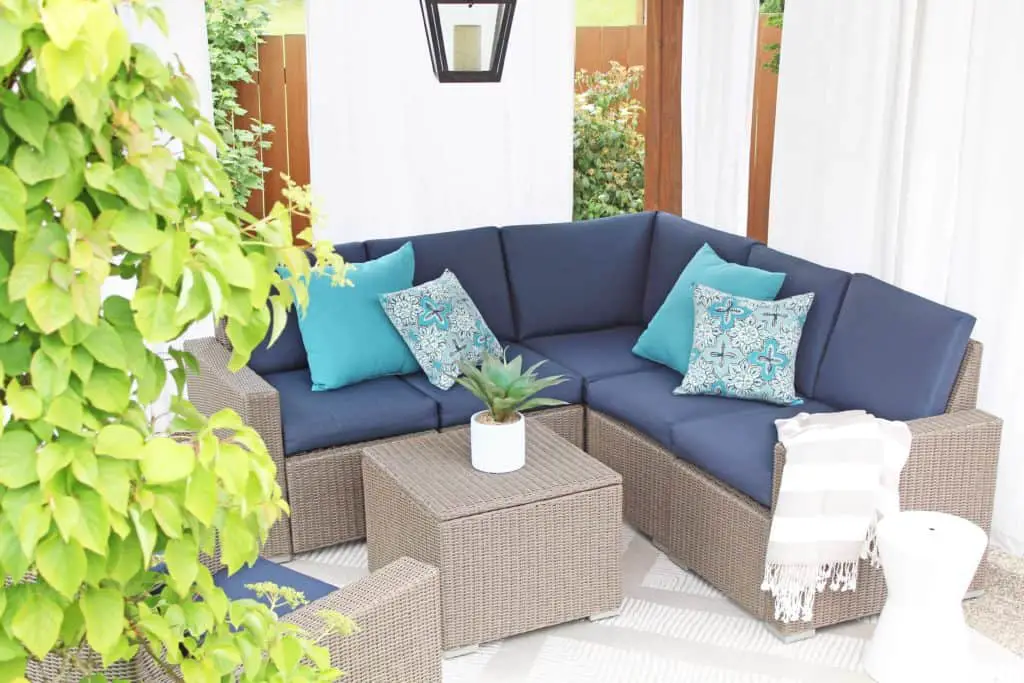 Summer is just around the corner, which means longer days and more outdoor time. Are you stuck on where to start with your outdoor space? Try these 5 simple patio makeover ideas.  #summerpatio #outdoorspace #outdoorlanterns #pergola #wickersectional #outdoorcurtains #outdoorrug #summerentertaining #outdoorlivingroom #bluedecor #aquadecor #backpatio #backyard #backdeck #smallyard