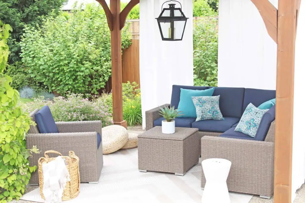 Summer is just around the corner, which means longer days and more outdoor time. Are you stuck on where to start with your outdoor space? Try these 5 simple patio makeover ideas.  #summerpatio #outdoorspace #outdoorlanterns #pergola #wickersectional #outdoorcurtains #outdoorrug #summerentertaining #outdoorlivingroom #bluedecor #aquadecor #backpatio #backyard #backdeck #smallyard