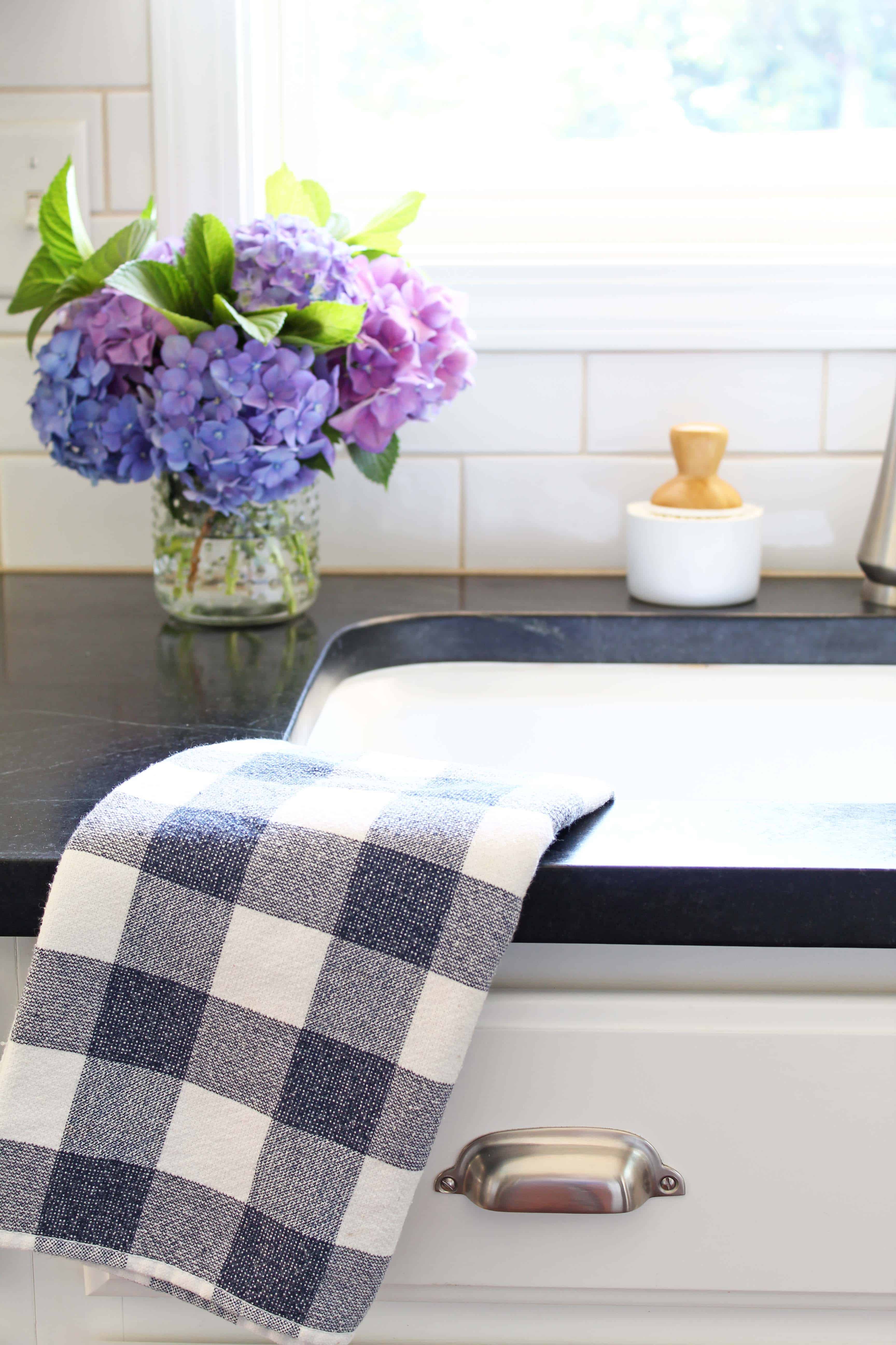 kitchen with soapstone counters, white subway tile, pink and purple hydrangeas