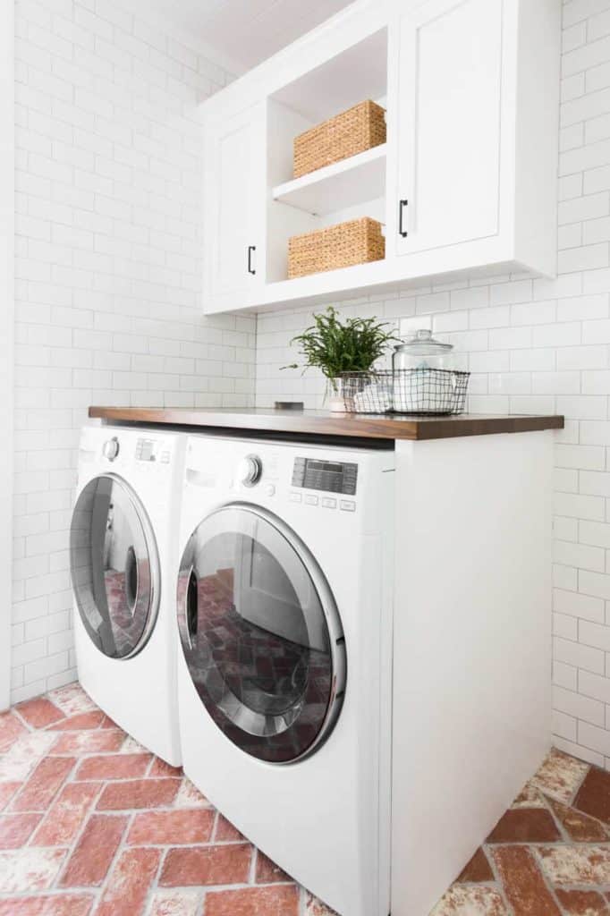 subway tile and brick laundry room 