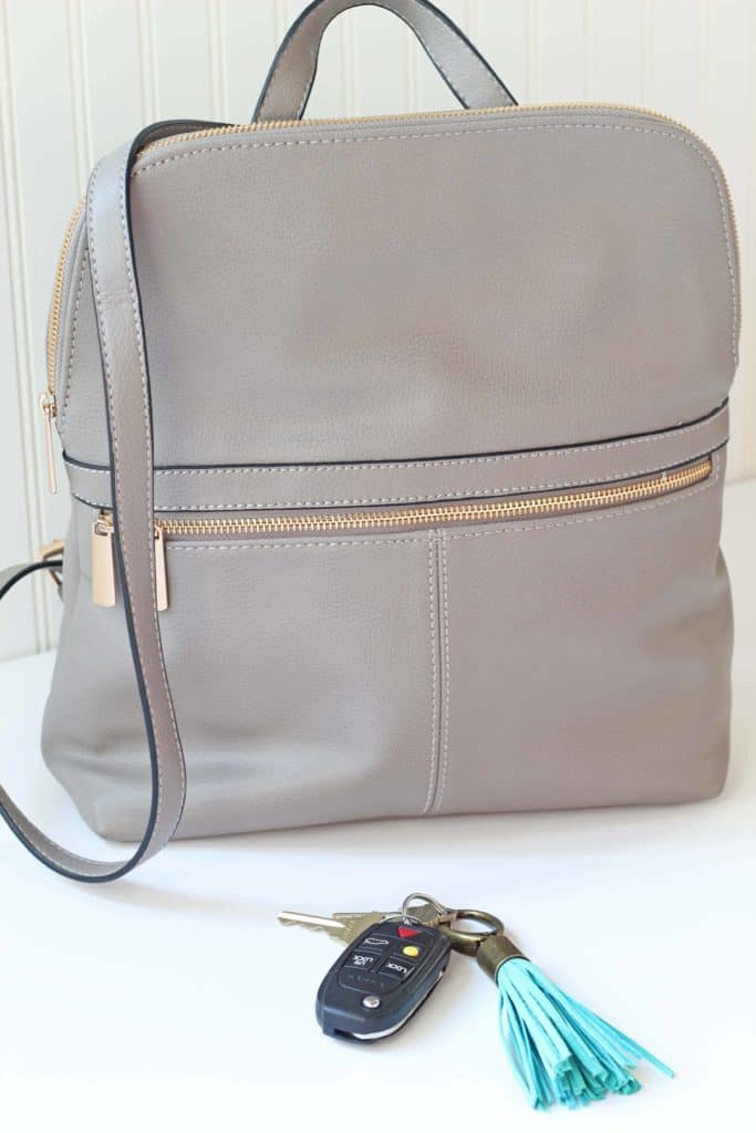 gray purse backpack with turquoise tassel keychain