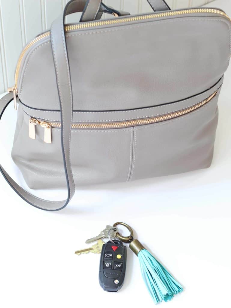 gray purse backpack with turquoise tassel keychain