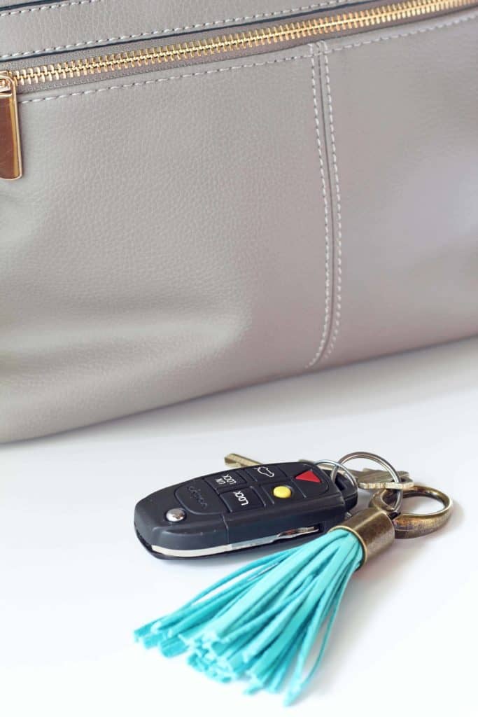 gray purse backpack with turquoise tassel keychain