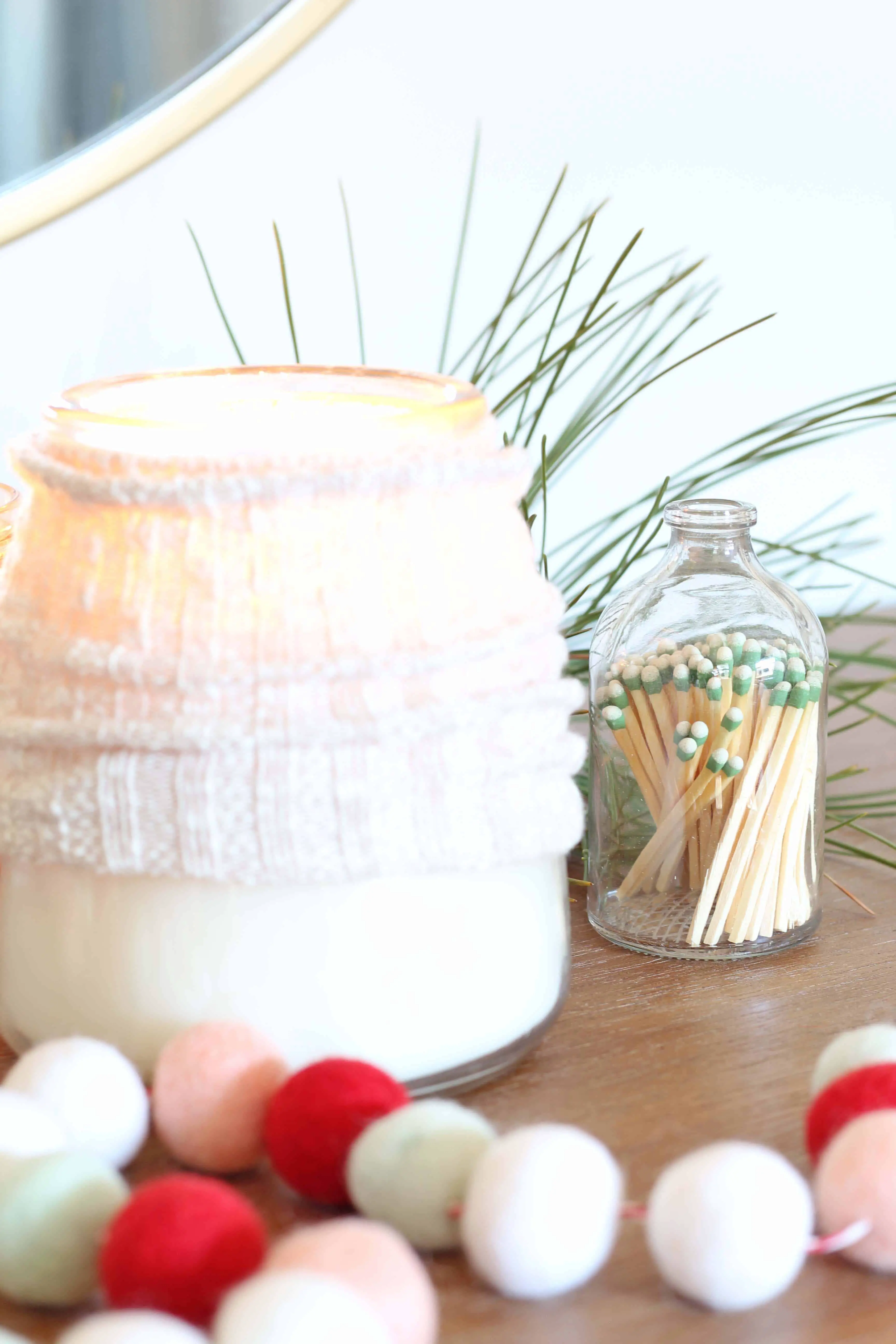candles with sweater cozy and pom pom garland