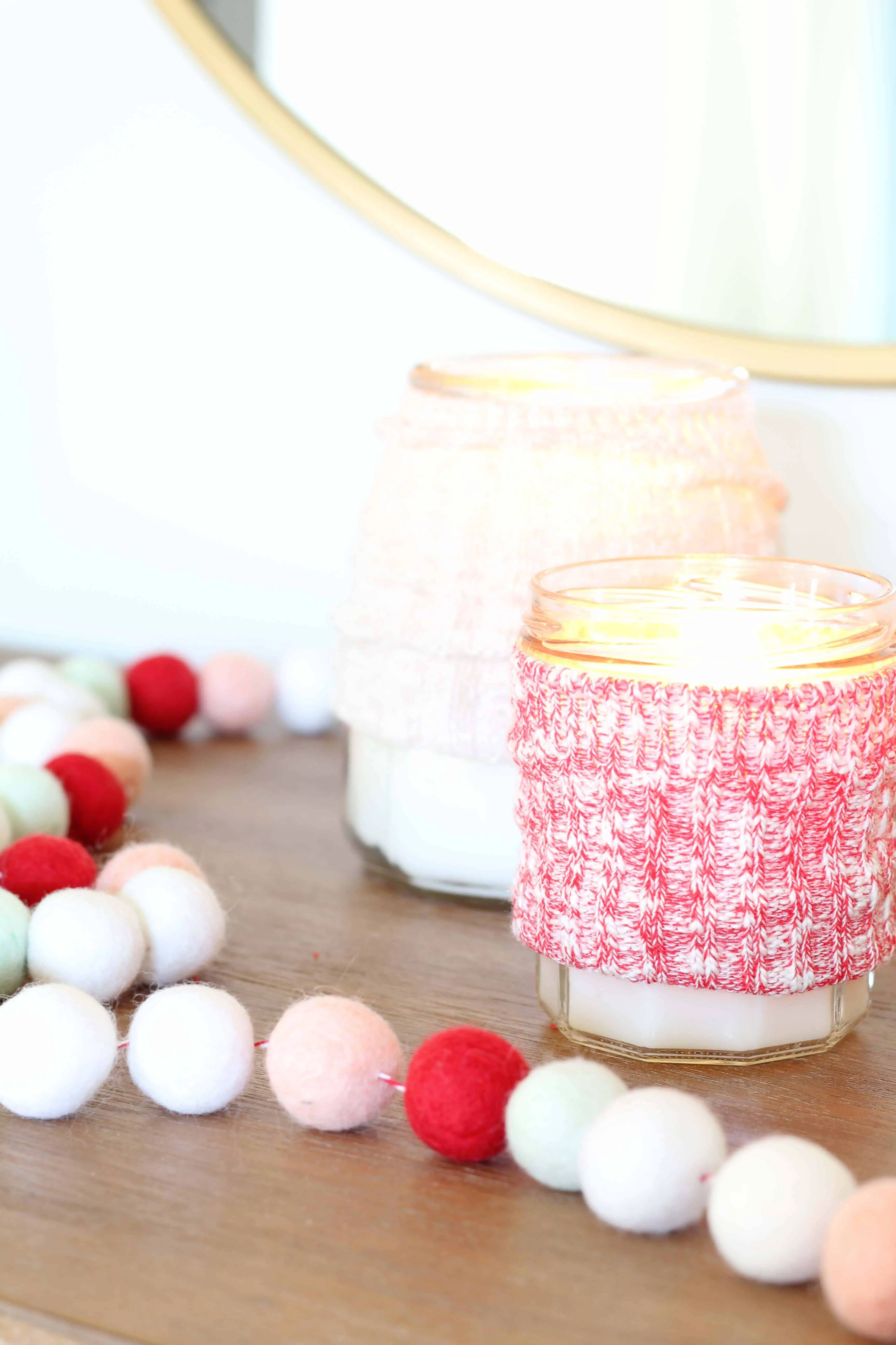candles with sweater cozy and pom pom garland