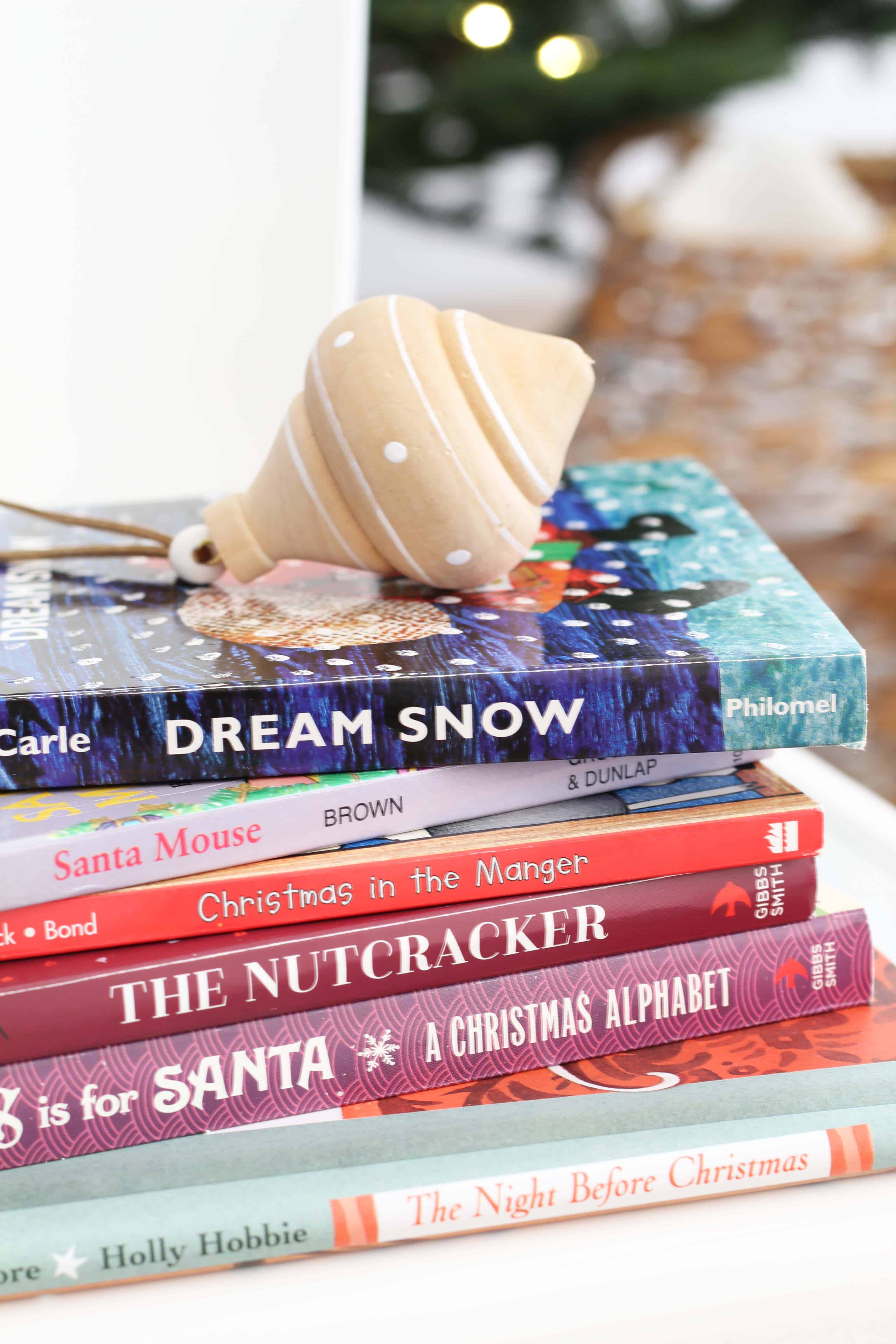 stack of children's christmas books with ornament 