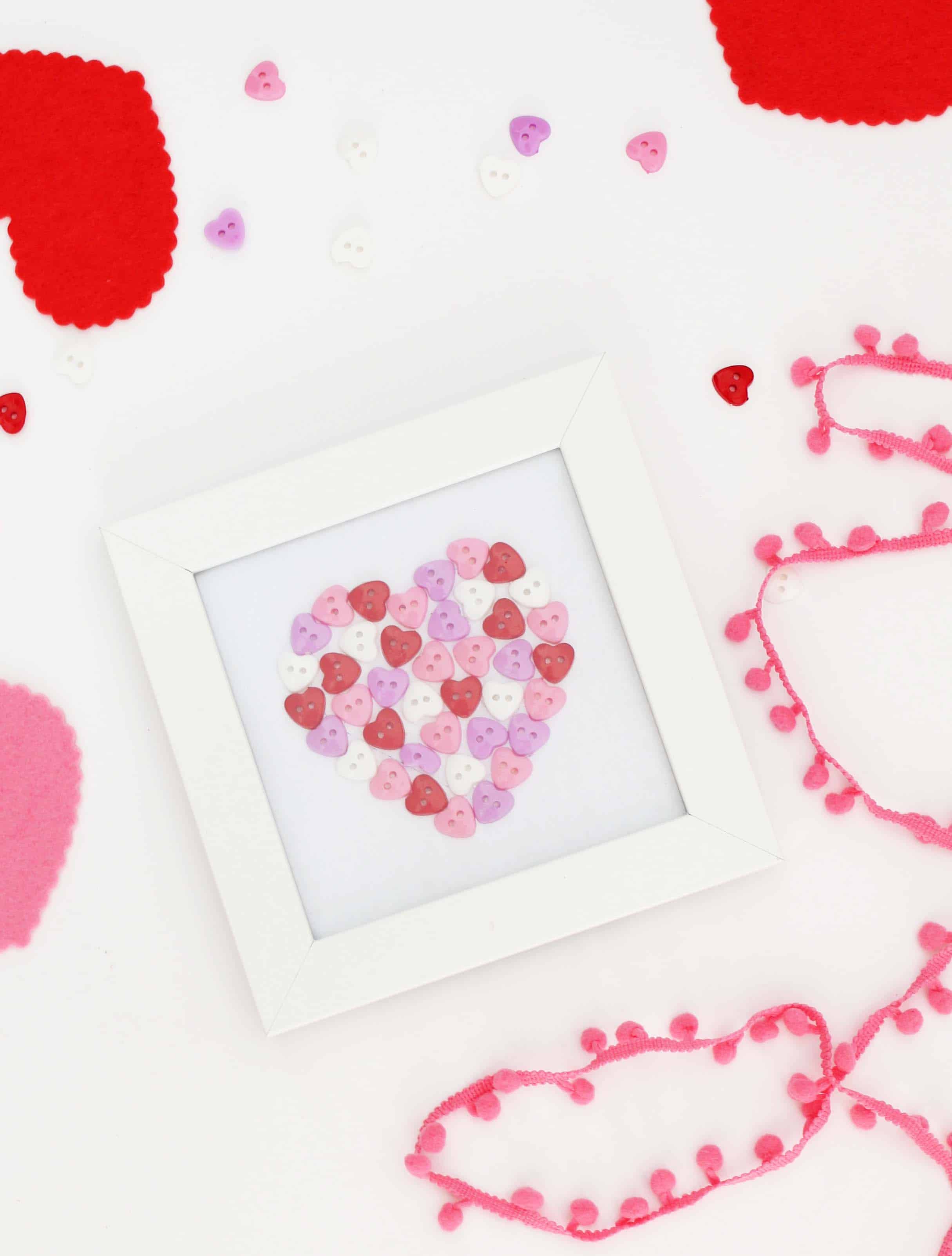 heart art made out of buttons in white picture frame