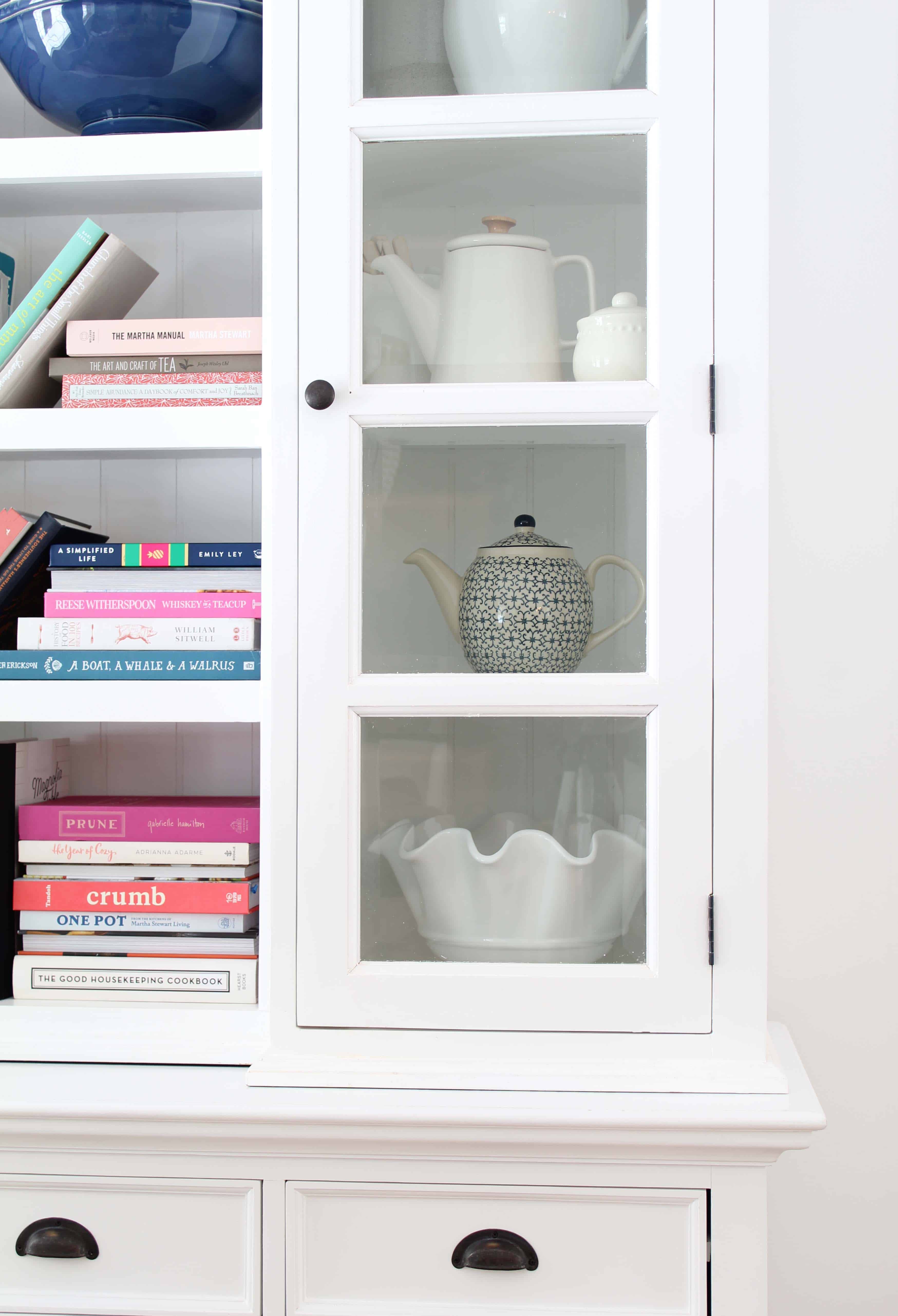 white library hutch with colorful books and teapots