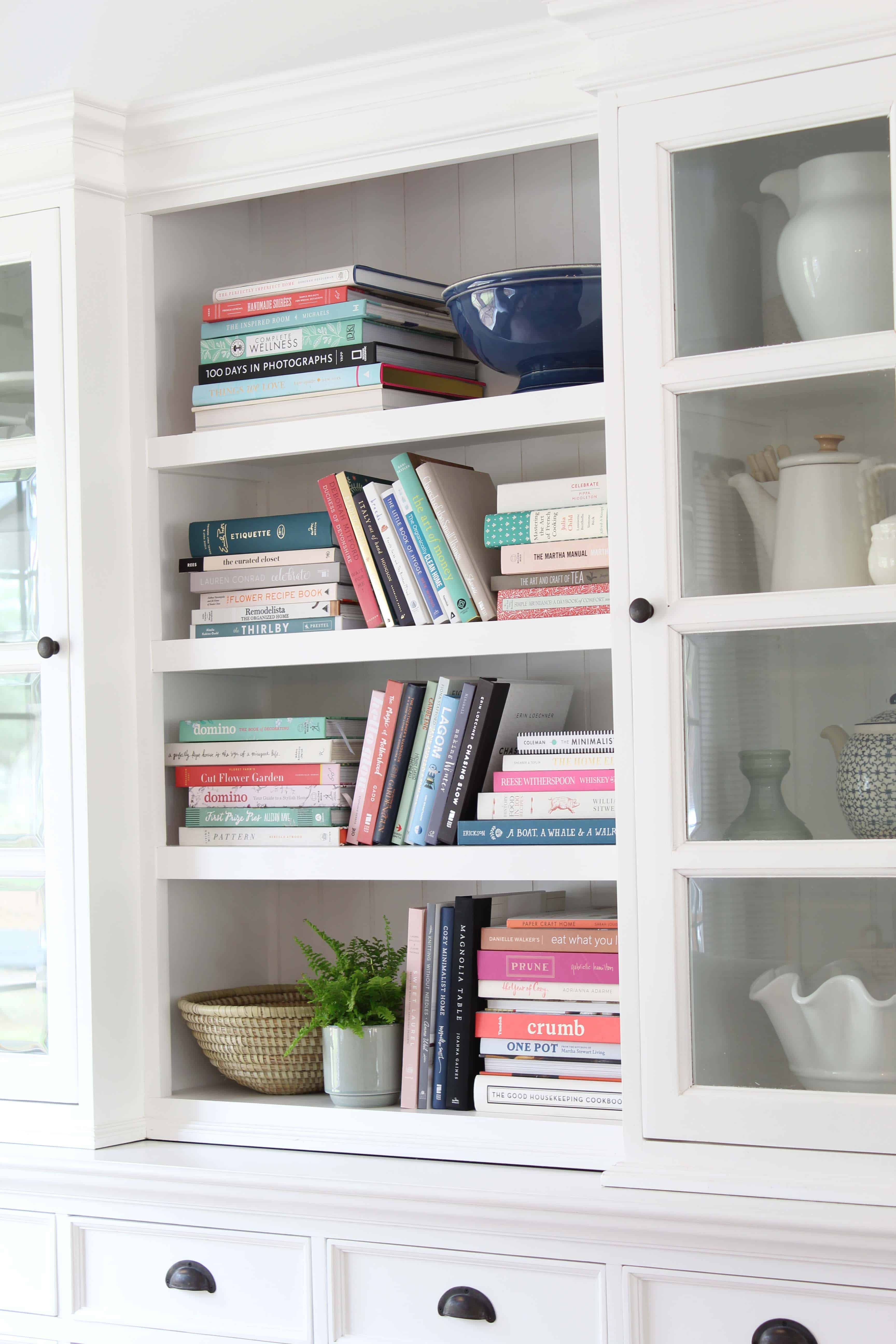 bookshelf full of colorful books, novasolo halifax library hutch, potted fern, african woven basket