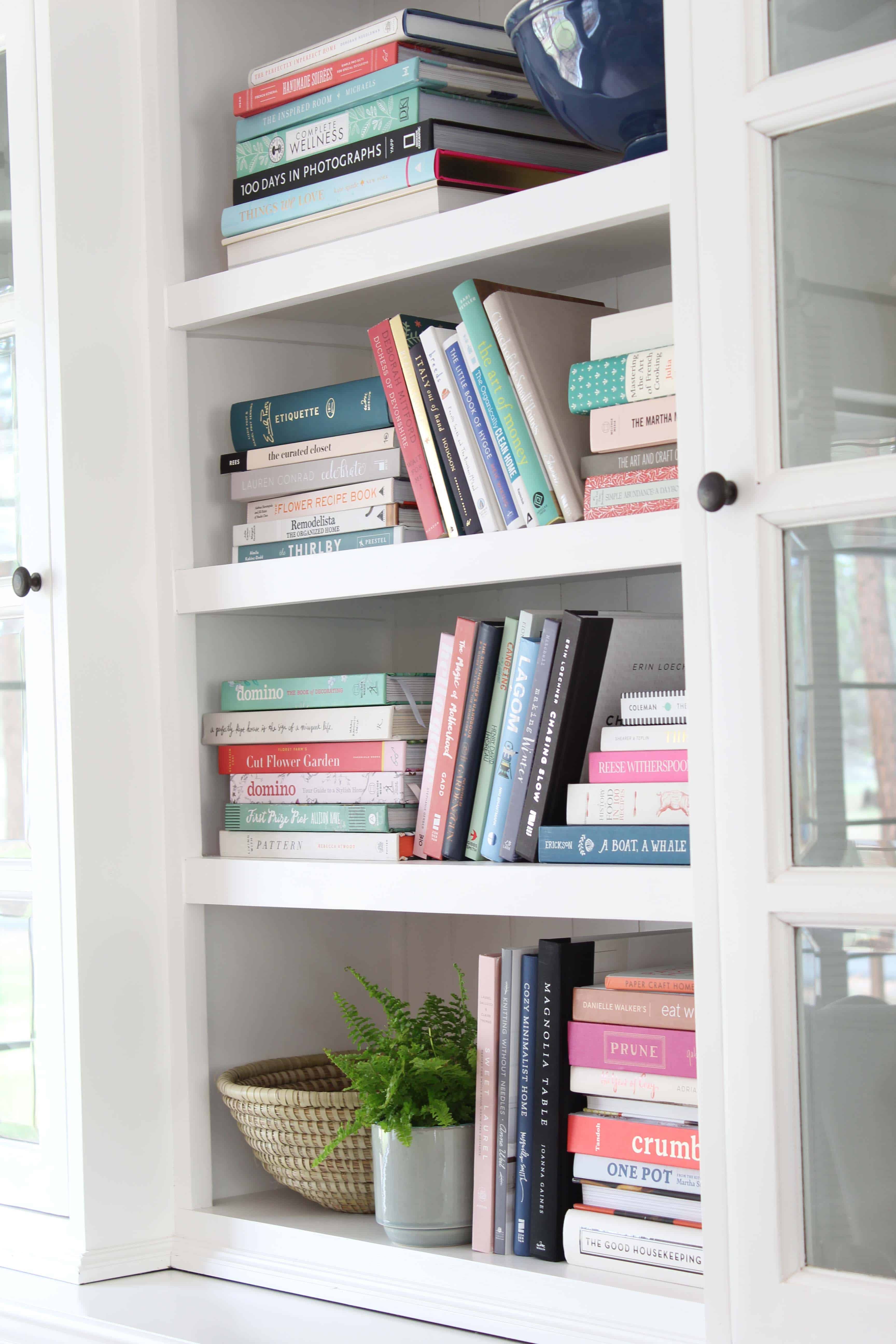 bookshelf full of colorful books, novasolo halifax library hutch, potted fern, african woven basket