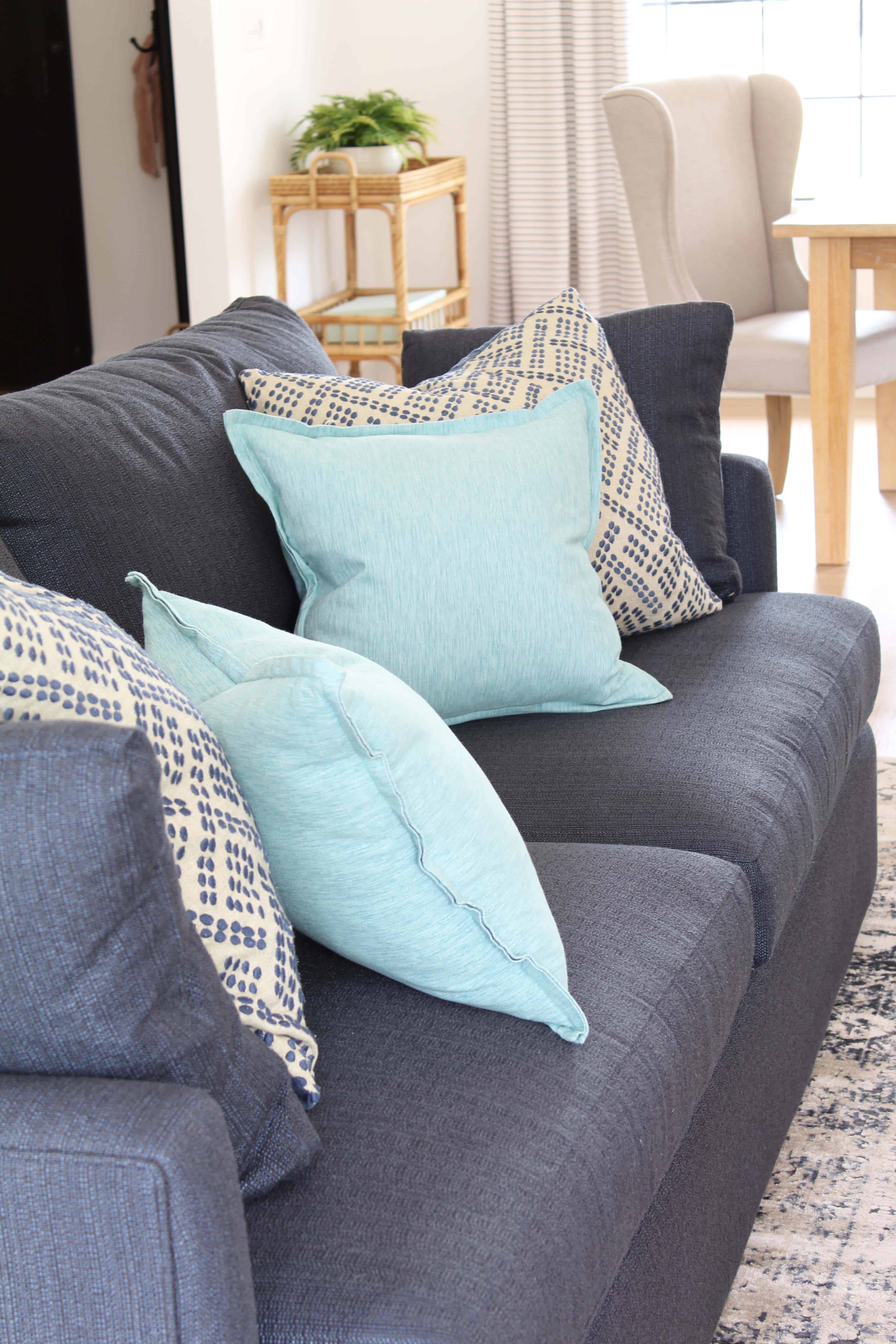 navy blue crate and barrel lounge II petite sofa with aqua throw pillows, upholstered wingback chair, serena and lily south seas bar cart