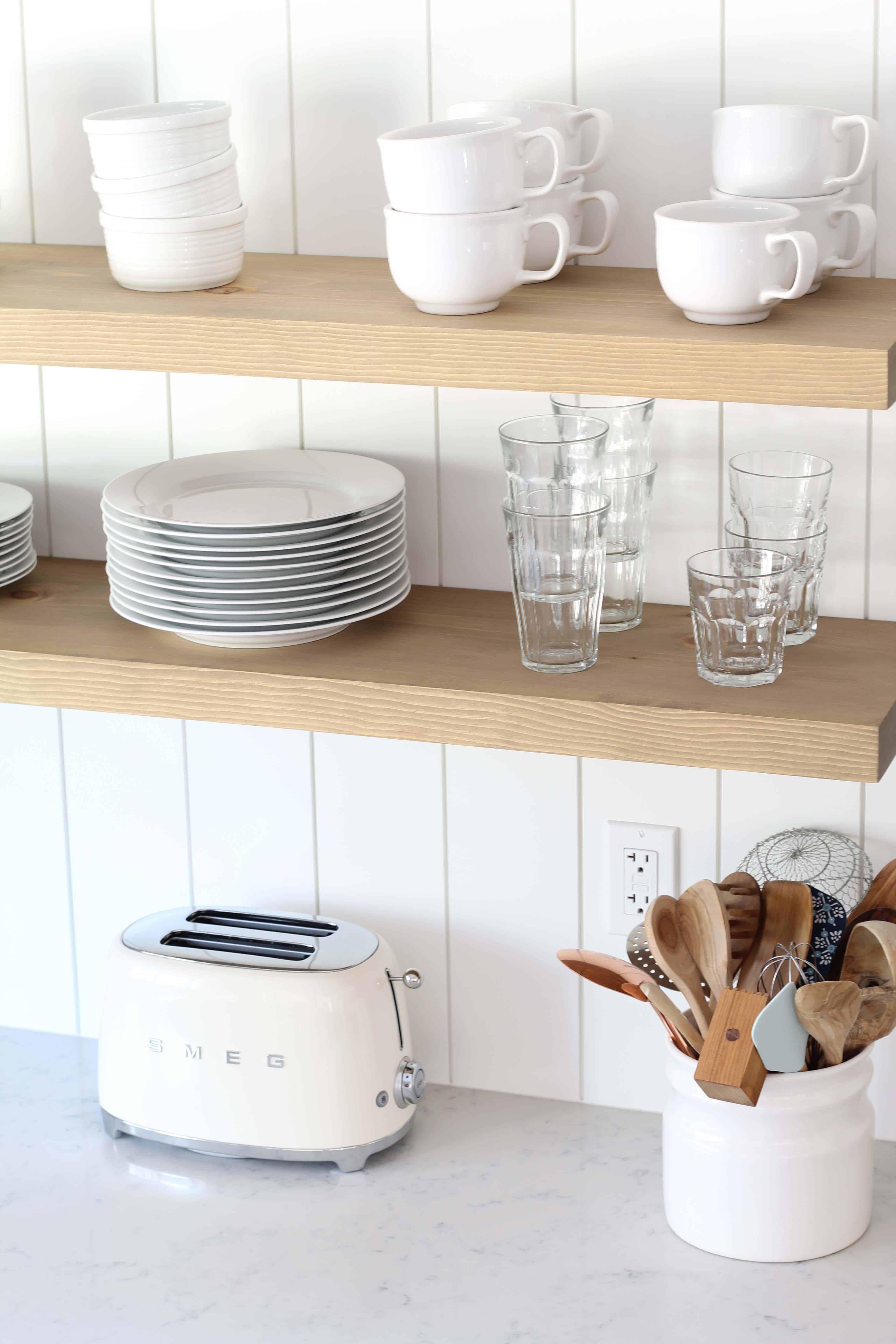 modern farmhouse kitchen with white vertical shiplap backsplash and open shelving and smeg toaster