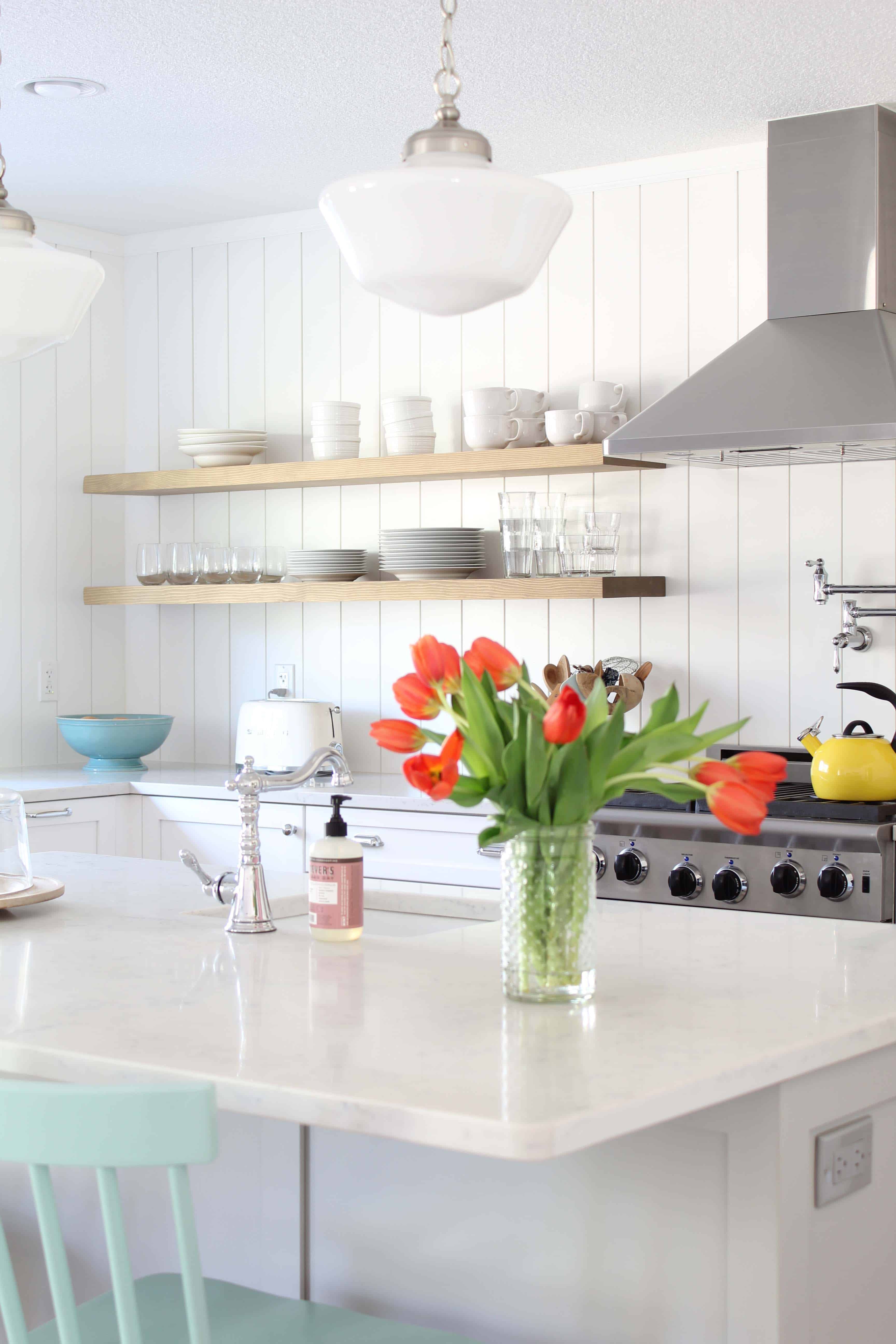 scandinavian style farmhouse kitchen, yellow chantal tea kettle, vertical board and batten kitchen backsplash, cream smog toaster, modern open kitchen shelving