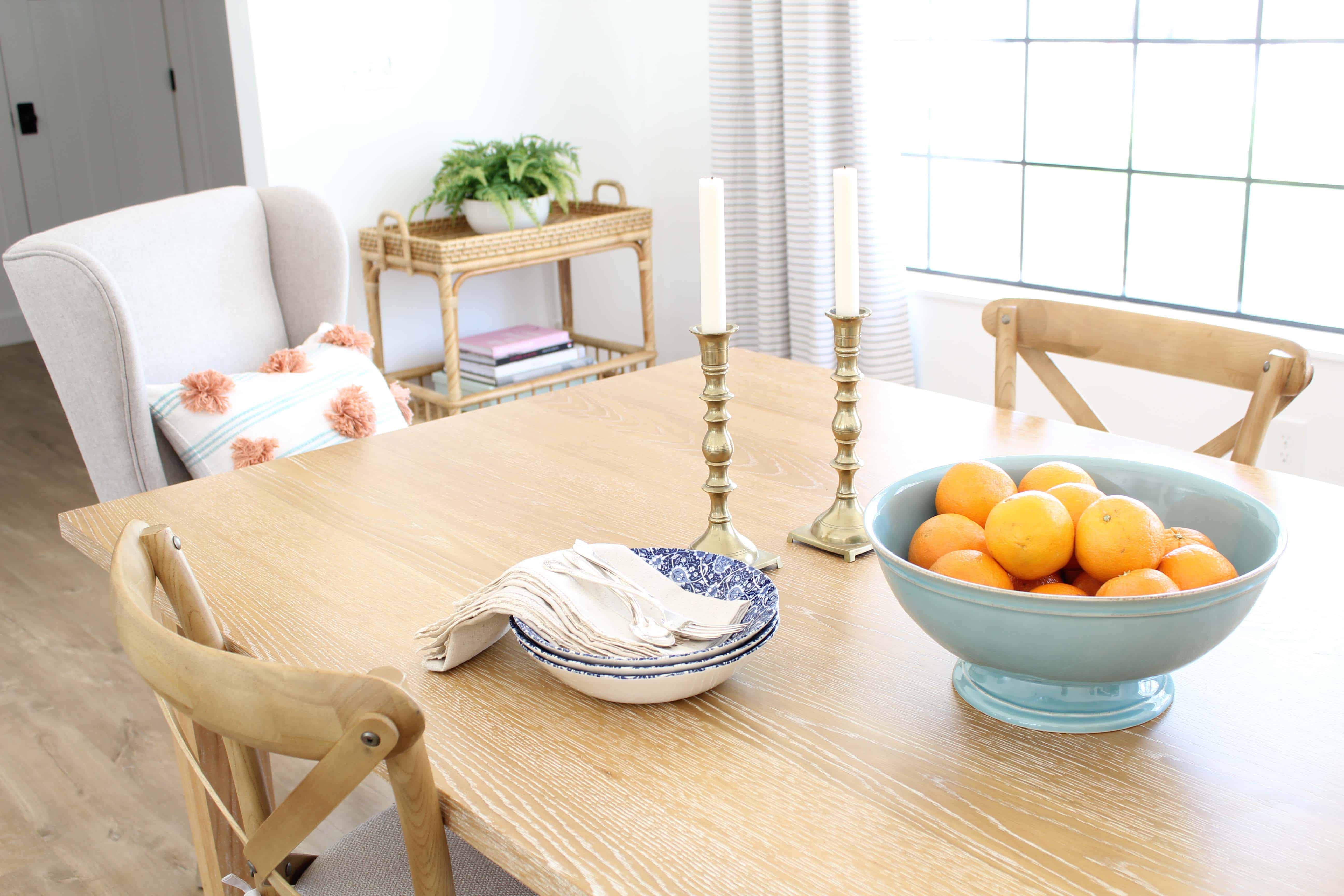 oranges in aqua bowl, brass candlesticks, blue transfer ware bowls with antique silverware, anthropologie pom pom pillow