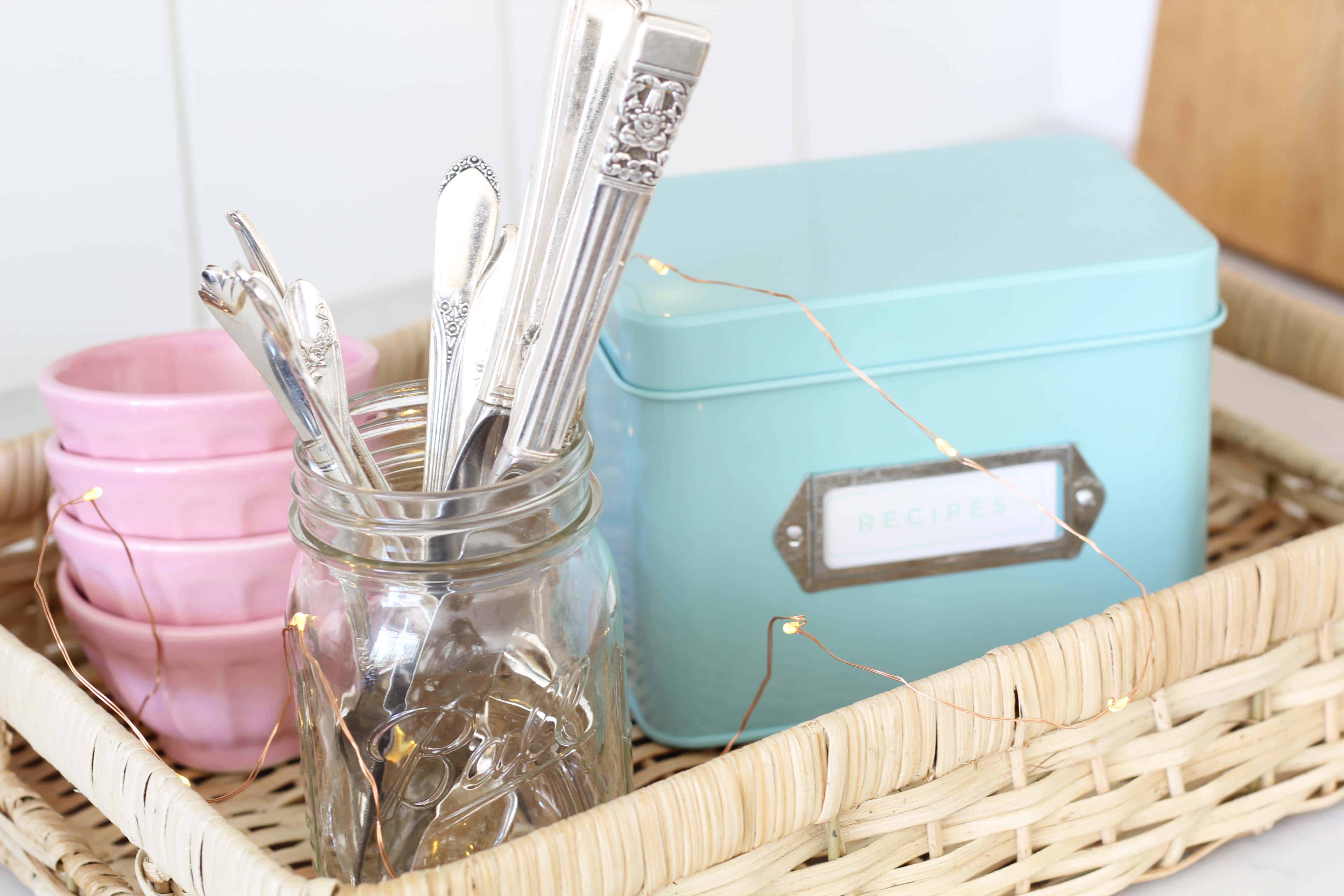 vintage silverware in a mason jar, anthropologie pink mini latte bowls, aqua recipe tin, mini fairy lights