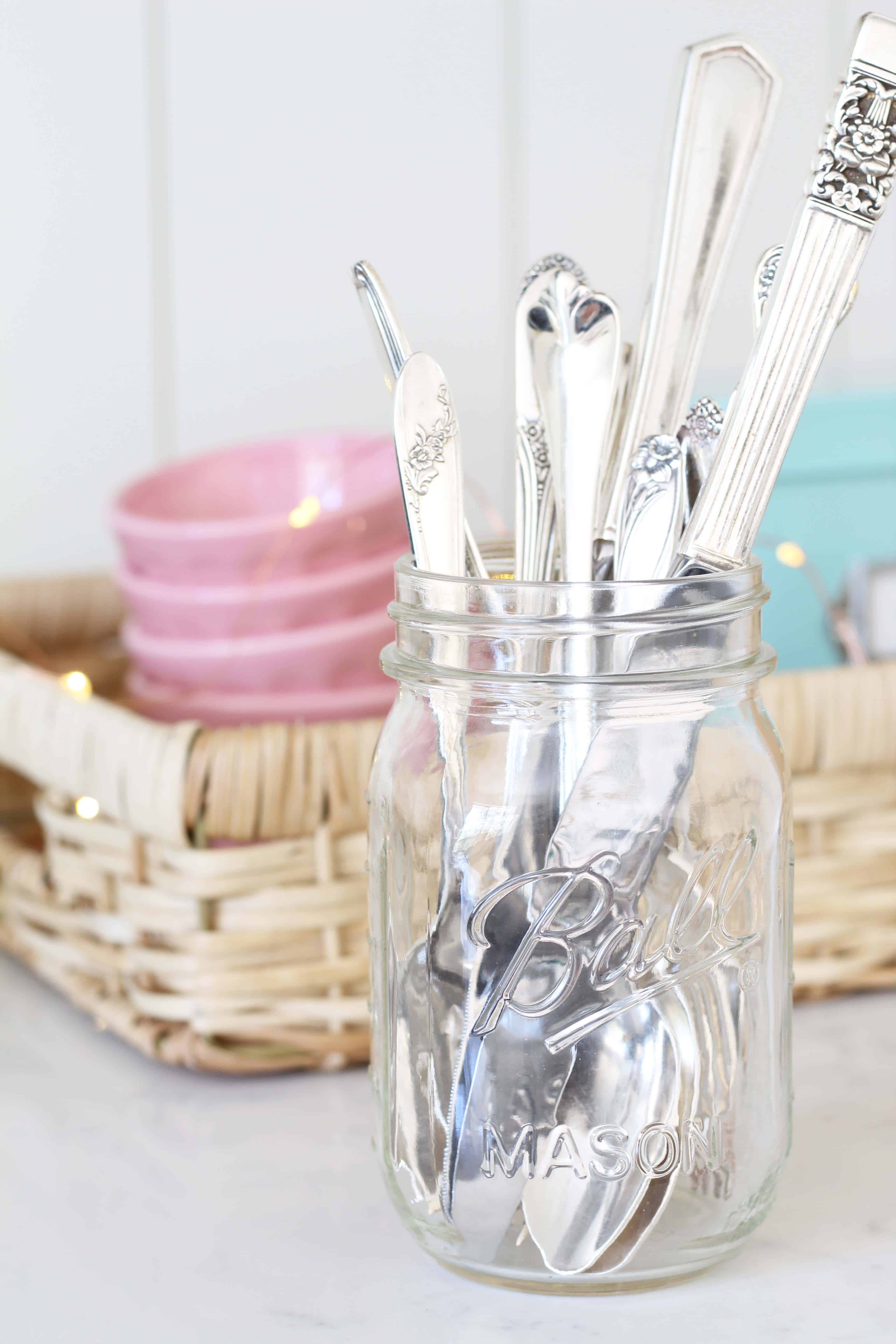 vintage silverware in a mason jar, anthropologie pink mini latte bowls, aqua recipe tin, mini fairy lights