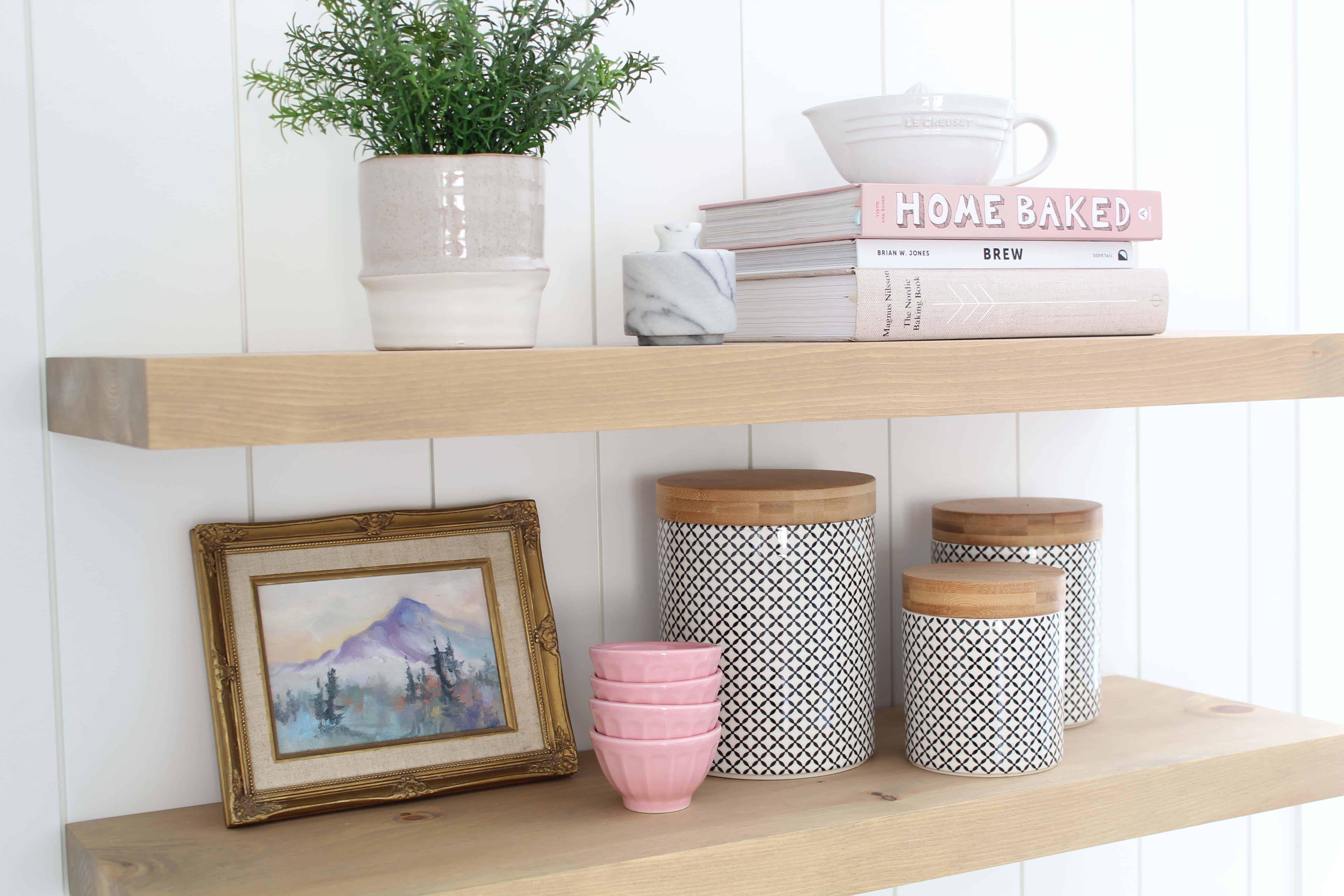 vintage landscape painting in gold frame, marble salt pinch container, anthropologie pink mini latte bowls, studio McGee farmhouse plant pot, le creuset ceramic juicer, homebaked book, nordic baking book, brew book 