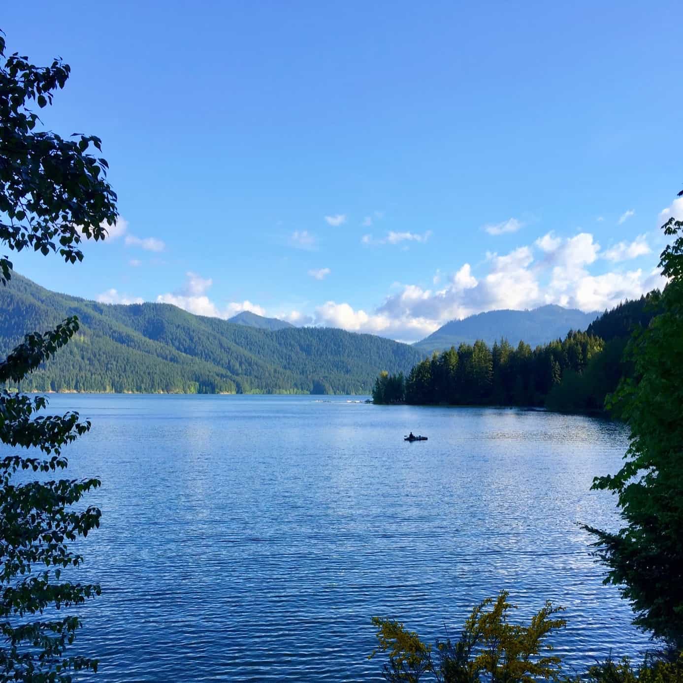 kayaker in lake surrounded by mountains