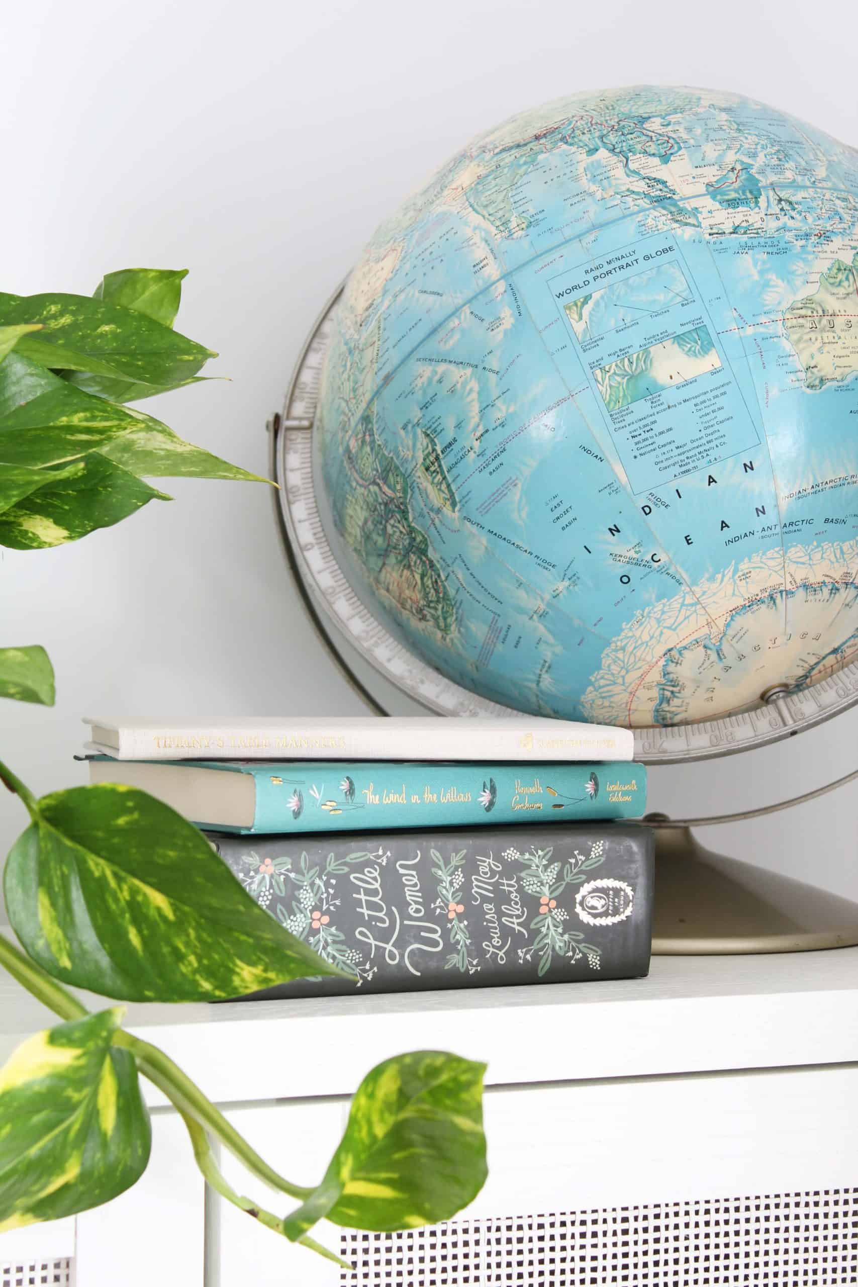 vintage globe, rifle paper co little women book, pothos plant