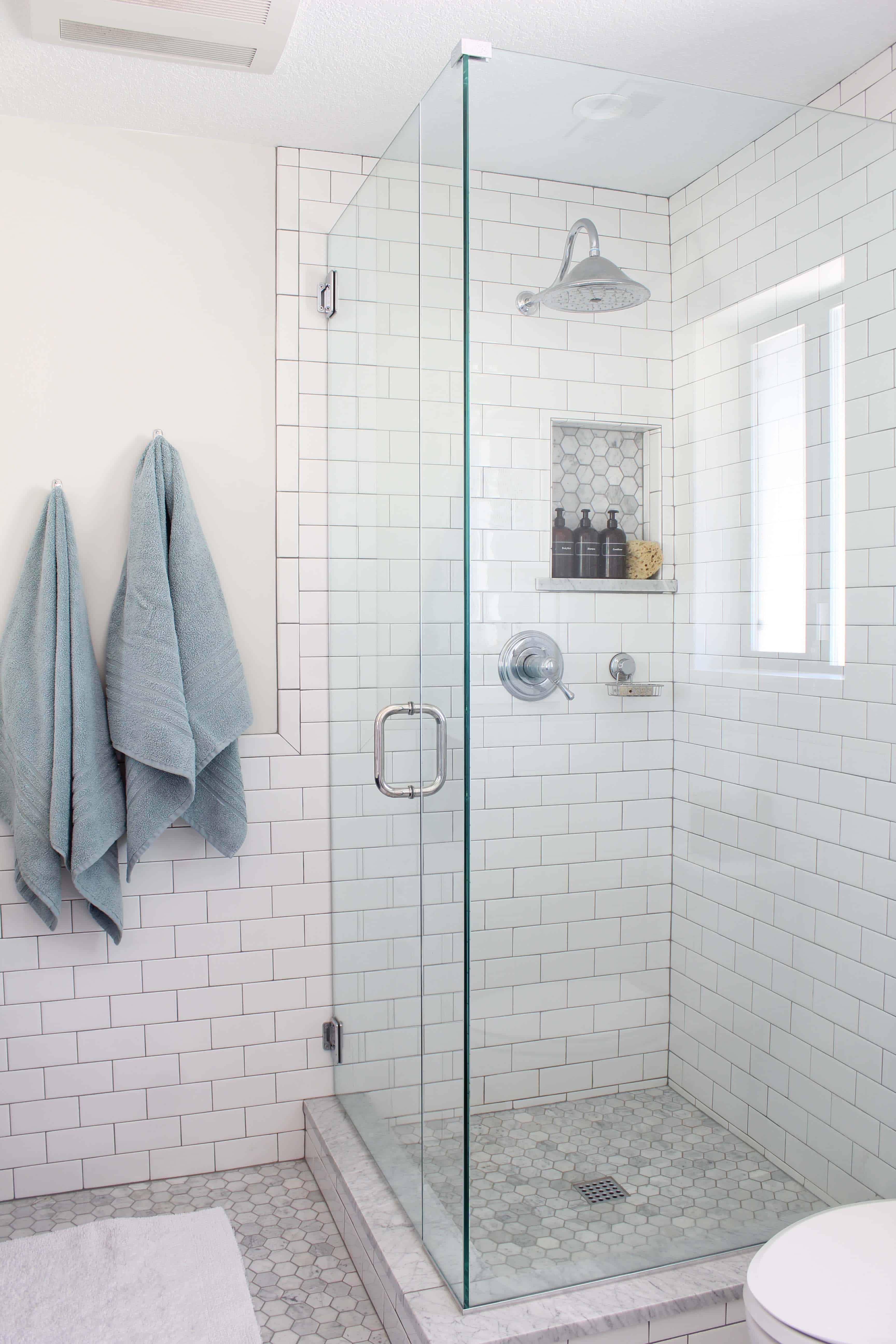 white subway tile and marble hex tile shower