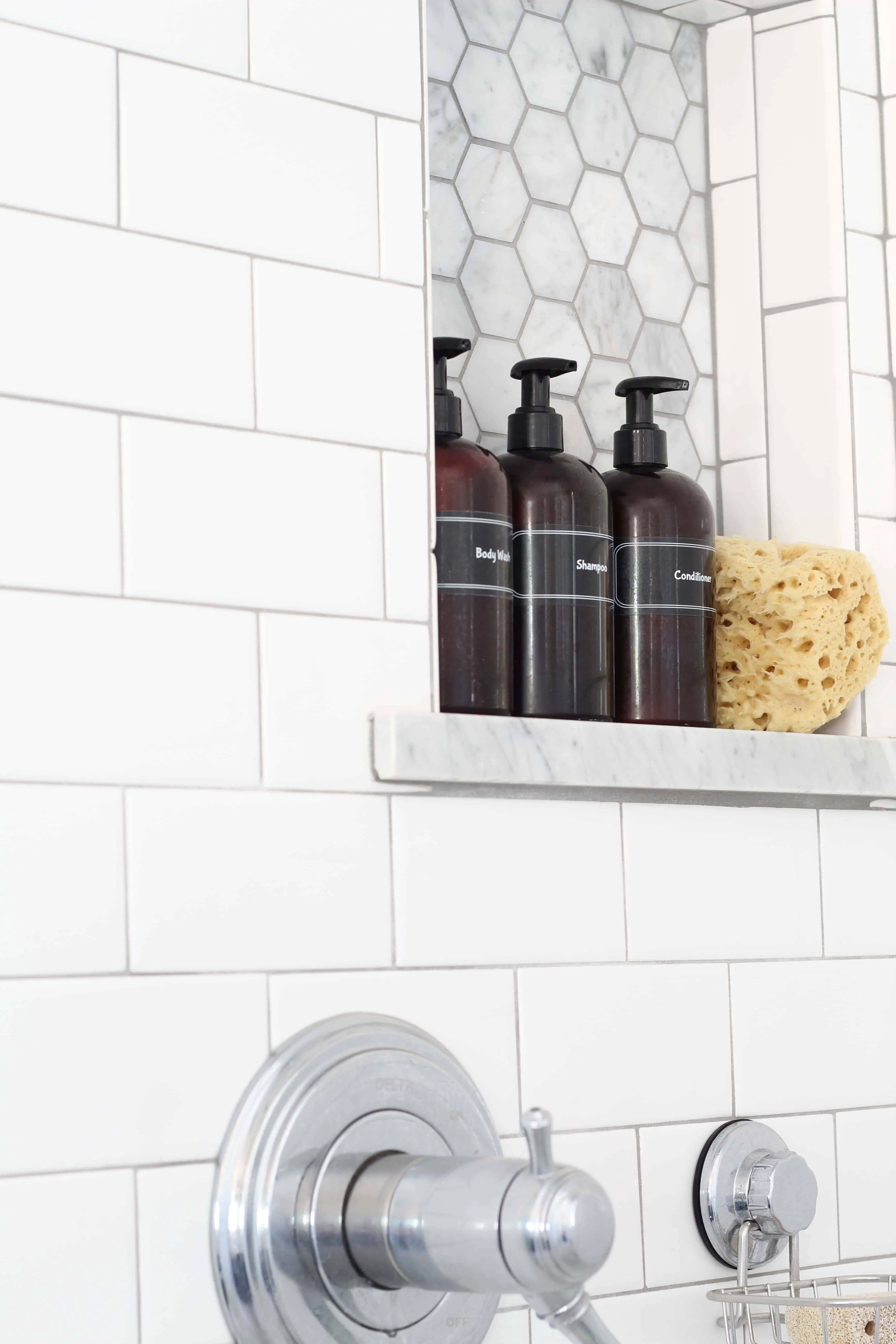 amber shower bottles and sea sponge, subway tile, marble hex tile