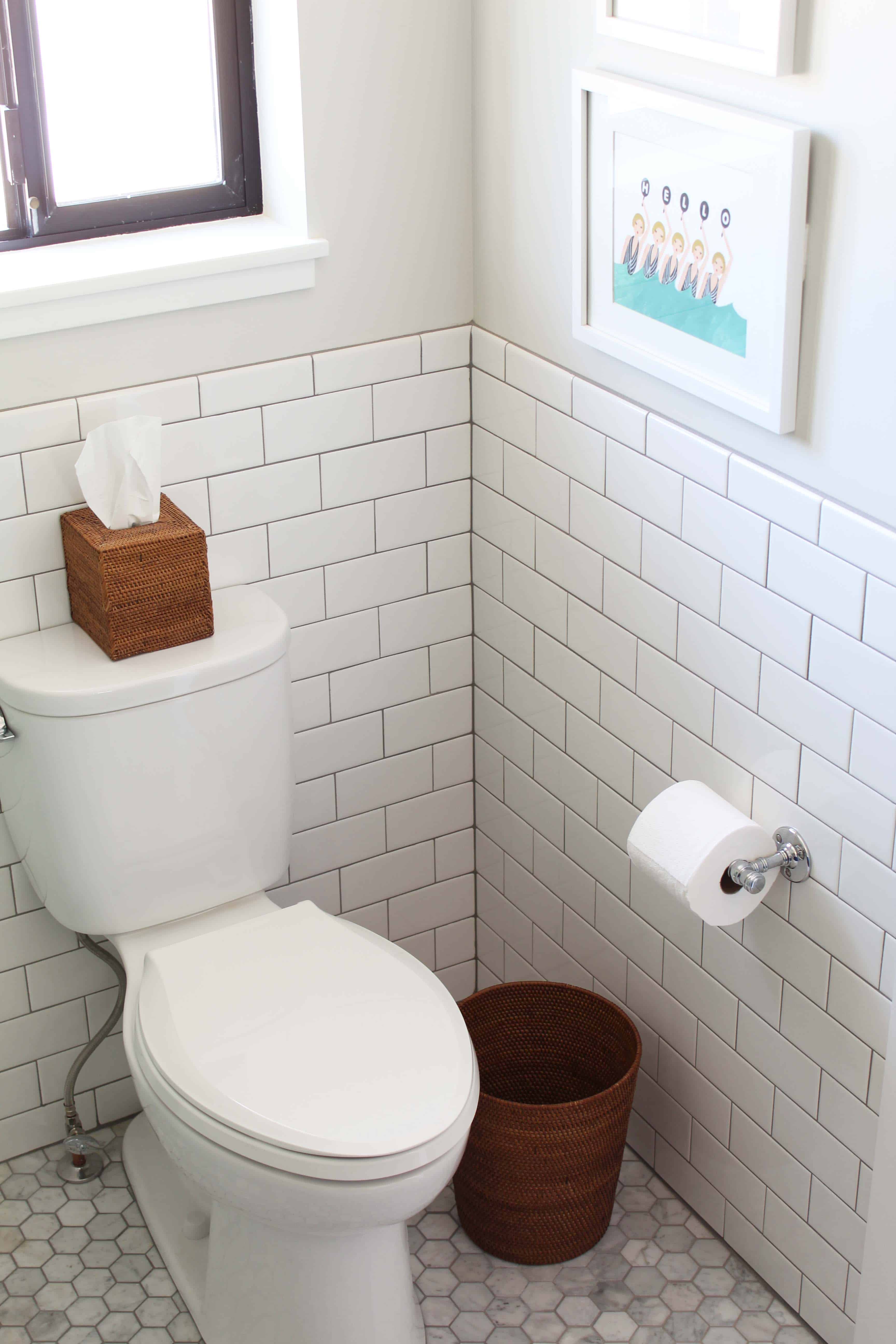 toilet with white subway tile surround