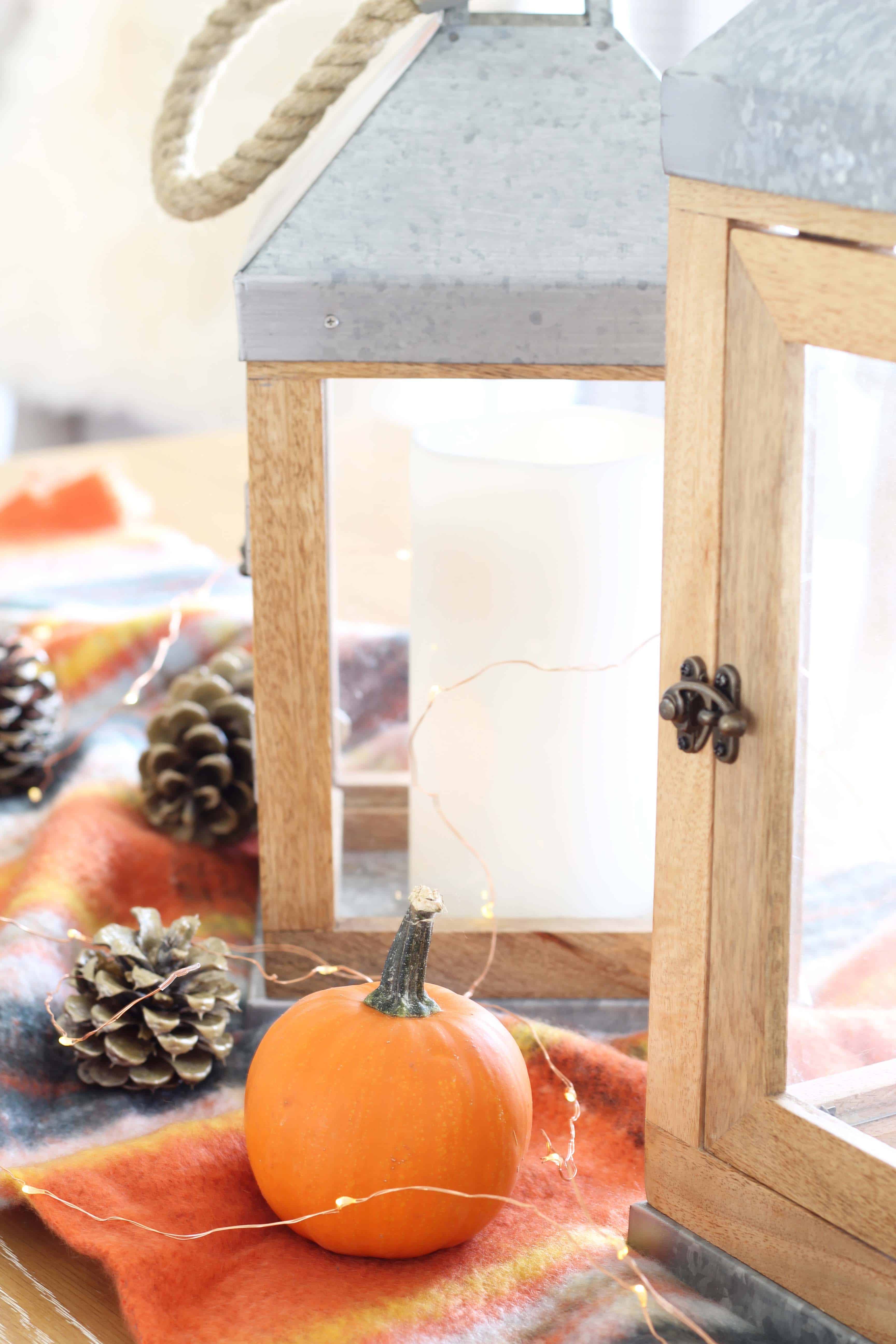 pinecones, aerie orange plaid blanket scarf, farmhouse wood lanterns, mini pumpkins