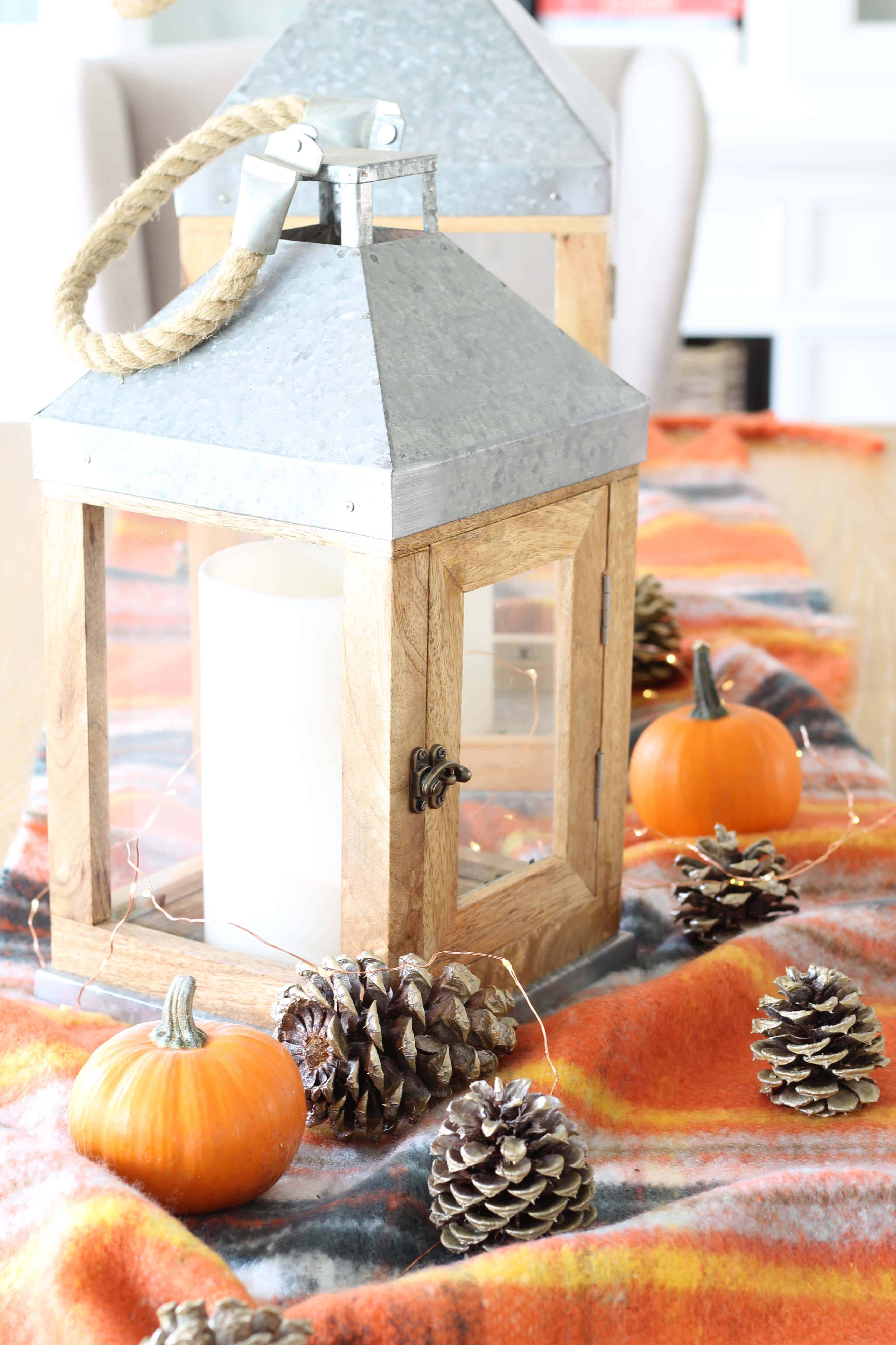 pinecones, aerie orange plaid blanket scarf, farmhouse wood lanterns, mini pumpkins