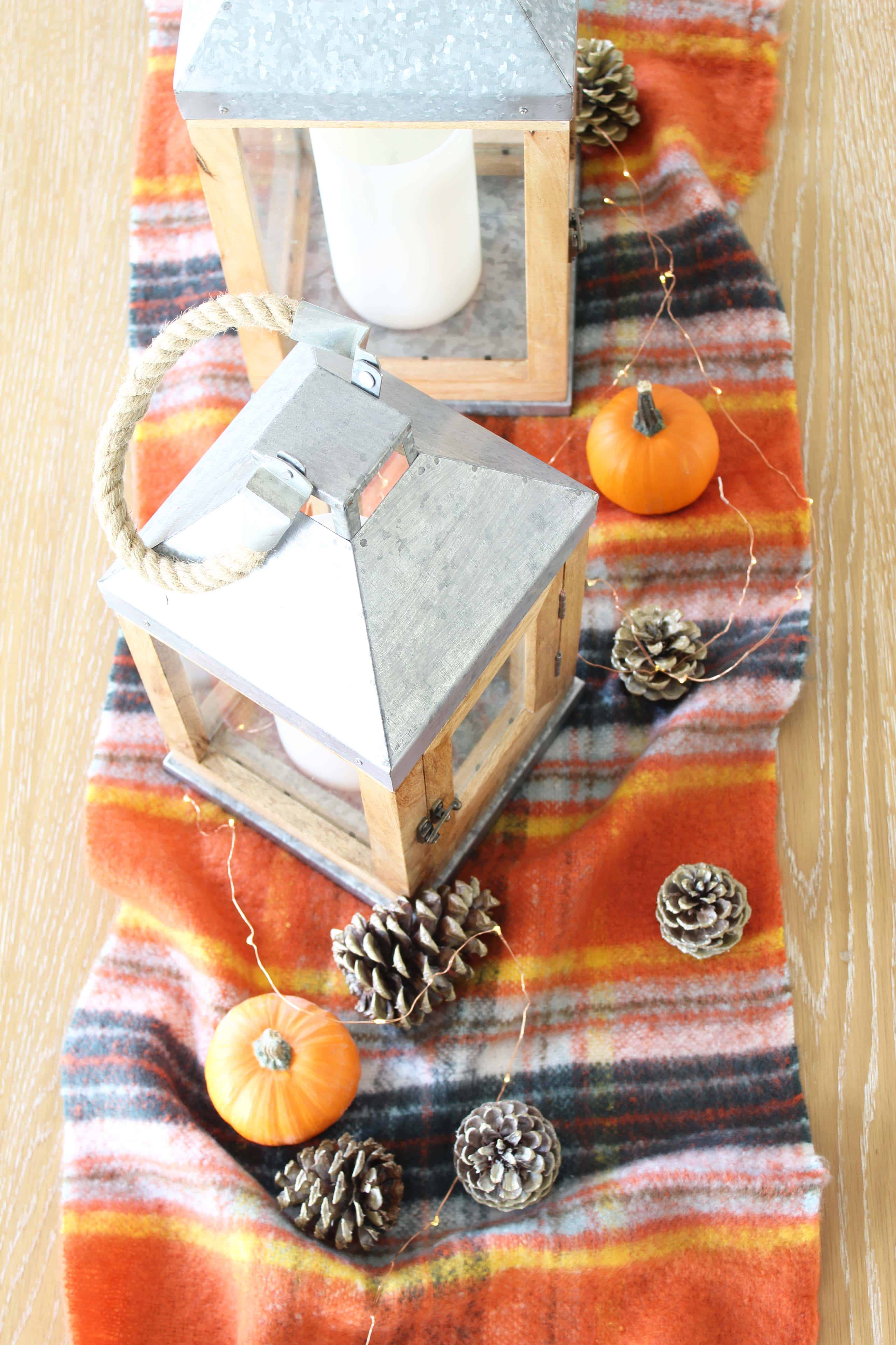 pinecones, aerie orange plaid blanket scarf, farmhouse wood lanterns, mini pumpkins