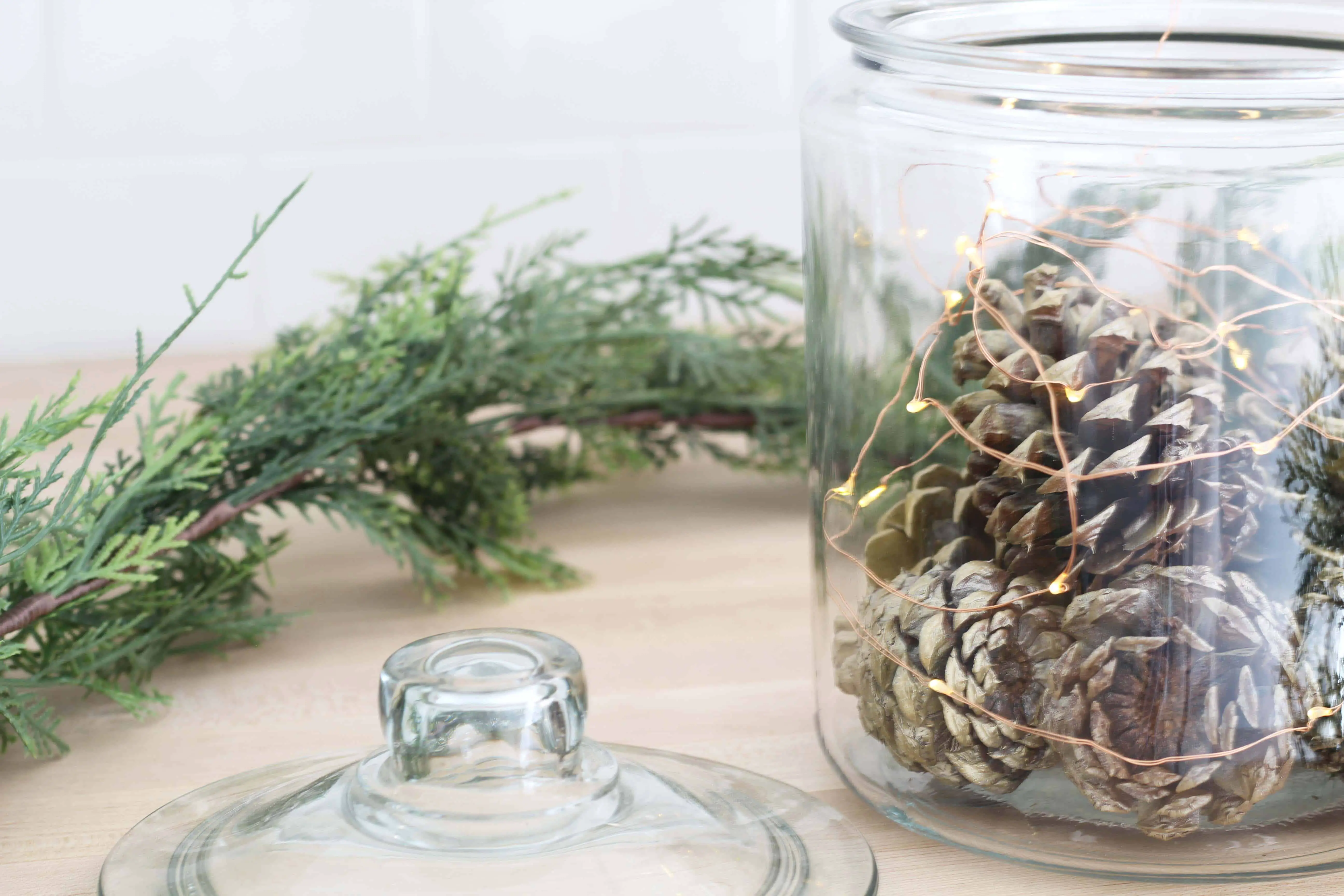 pinecones in glass canister with copper fairy lights , pier one faux pine garland