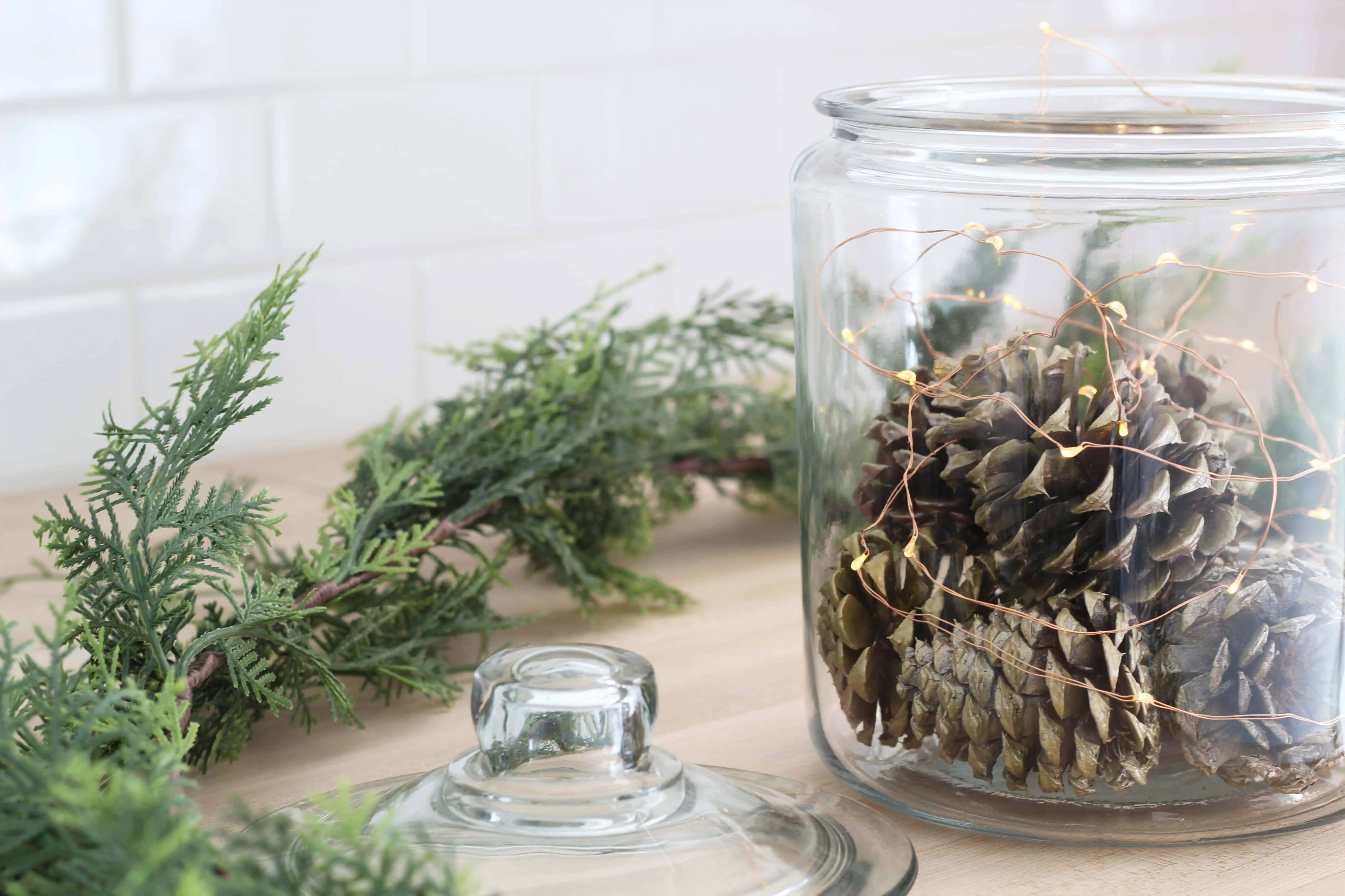 pinecones in glass canister with fairy lights