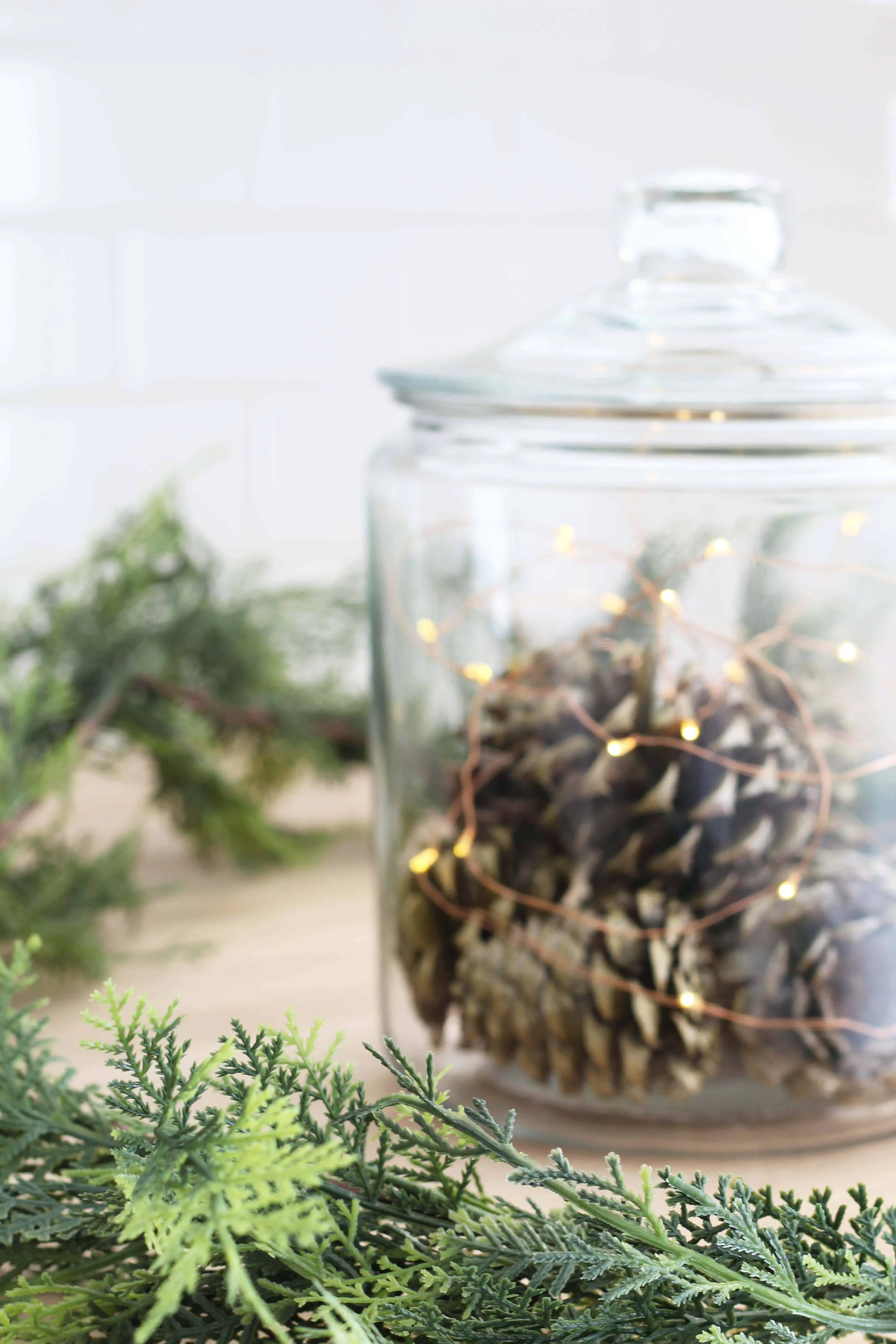 pinecones in glass canister with fairy lights, pier one faux pine garland