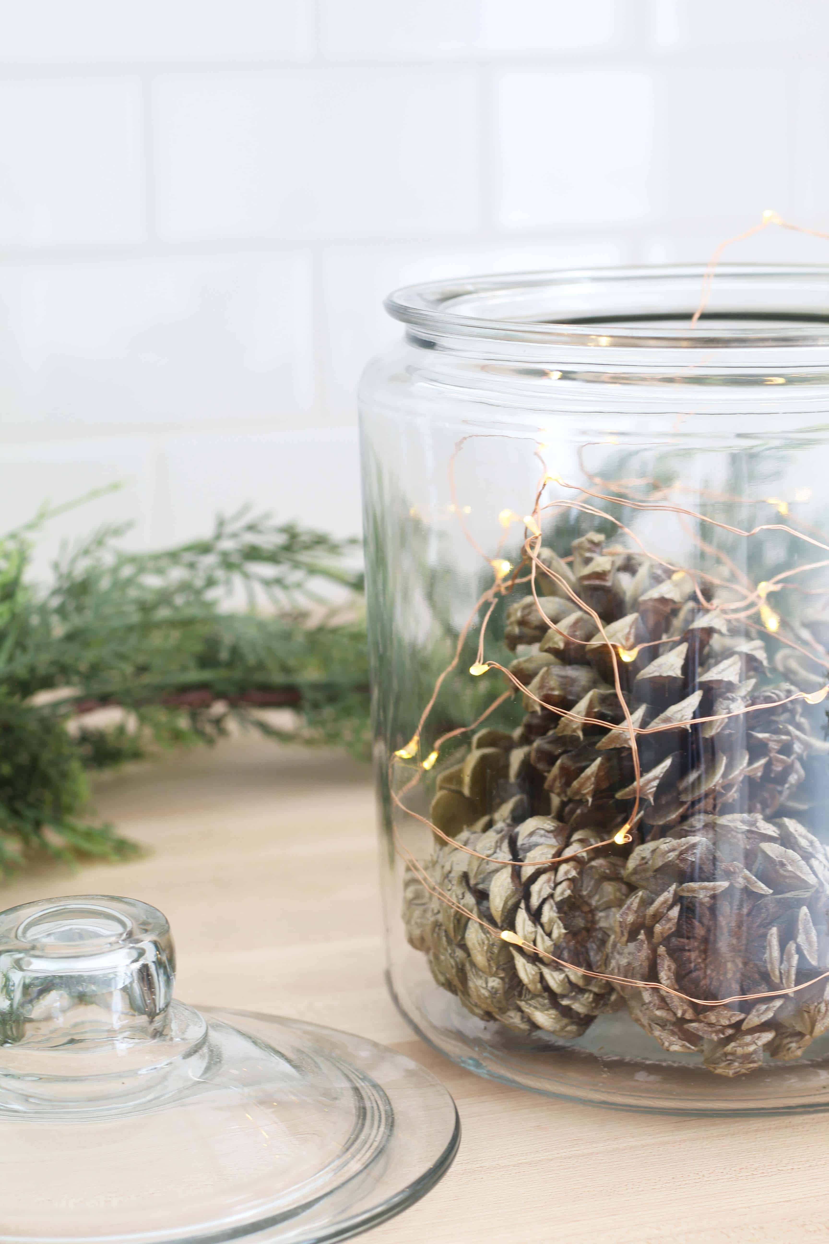 pinecones in glass canister with fairy lights