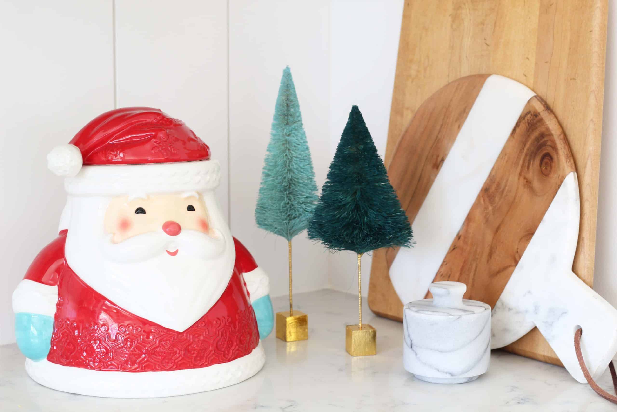 hallmark santa cookie jar, green glitterville bottle brush trees, marble salt cellar, marble stripe cheeseboard