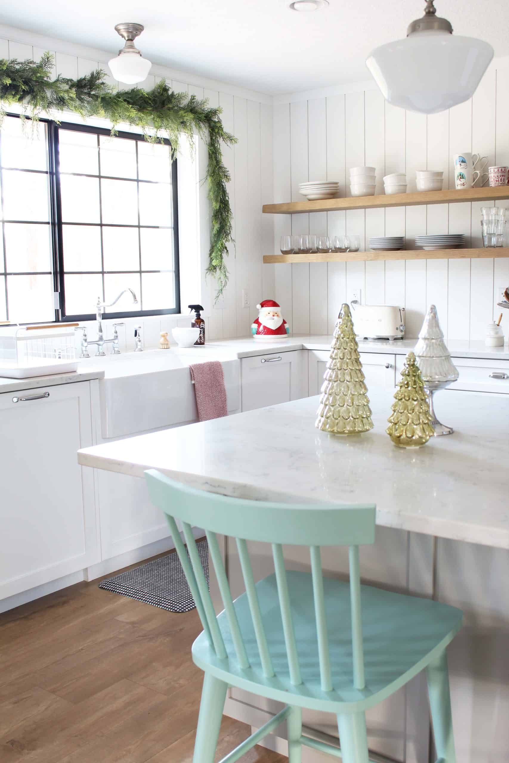 faux cedar garland over kitchen sink, aqua counter height windsor chairs, gold mercury trees, hallmark santa cookie jar 