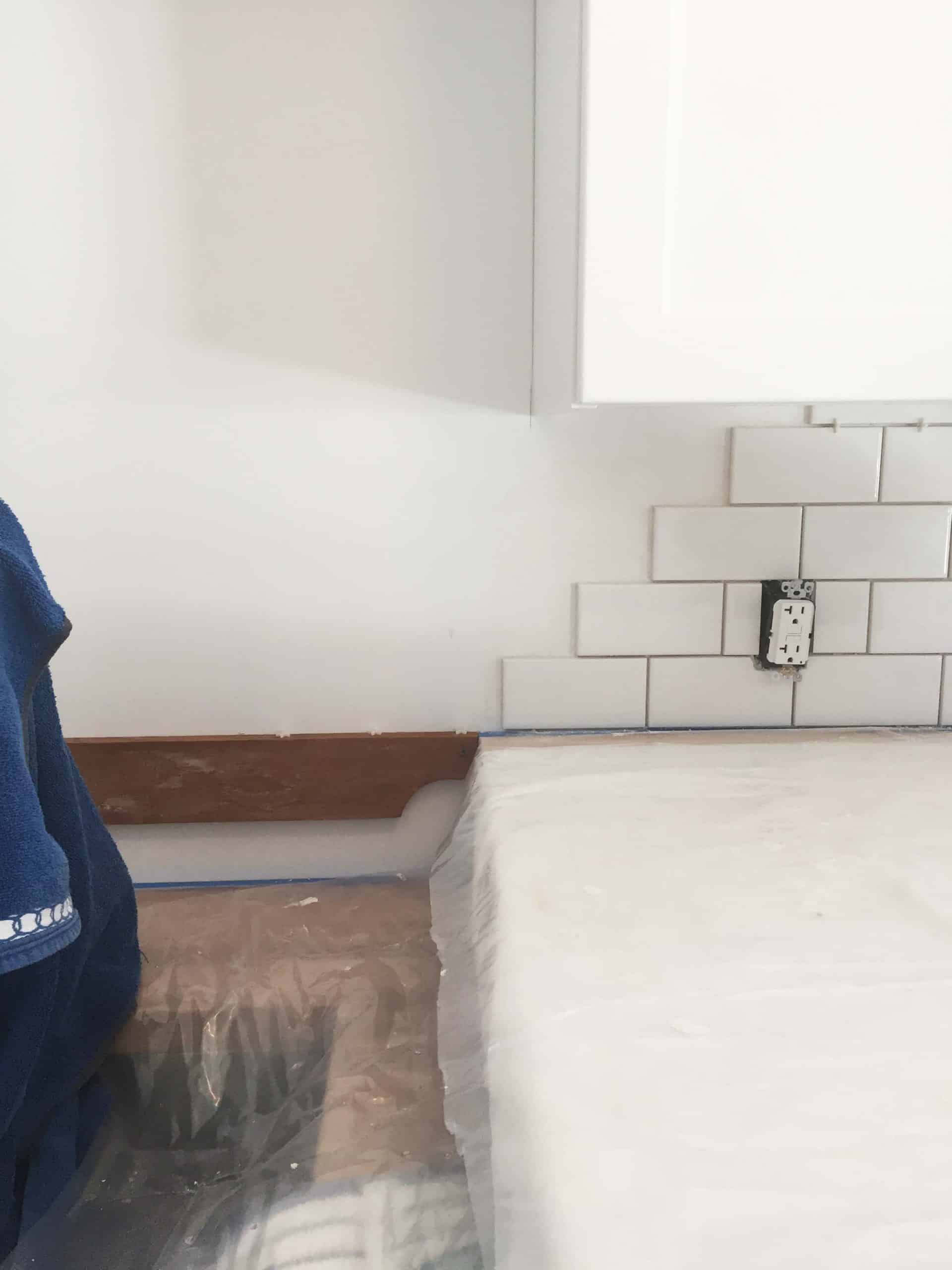 two different countertop heights in laundry room with subway tile backsplash