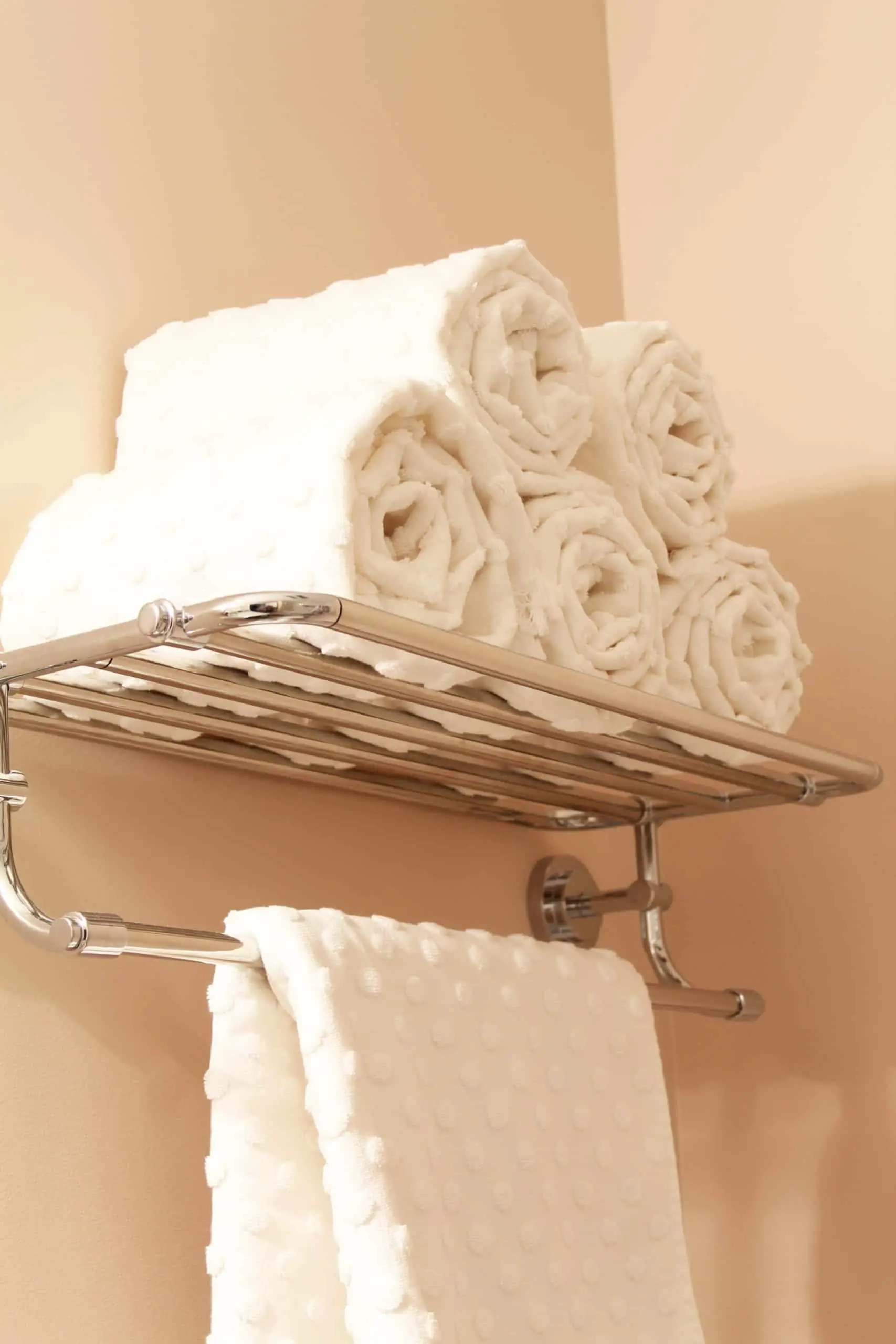 white polka dot towels rolled on a hotel towel rack 