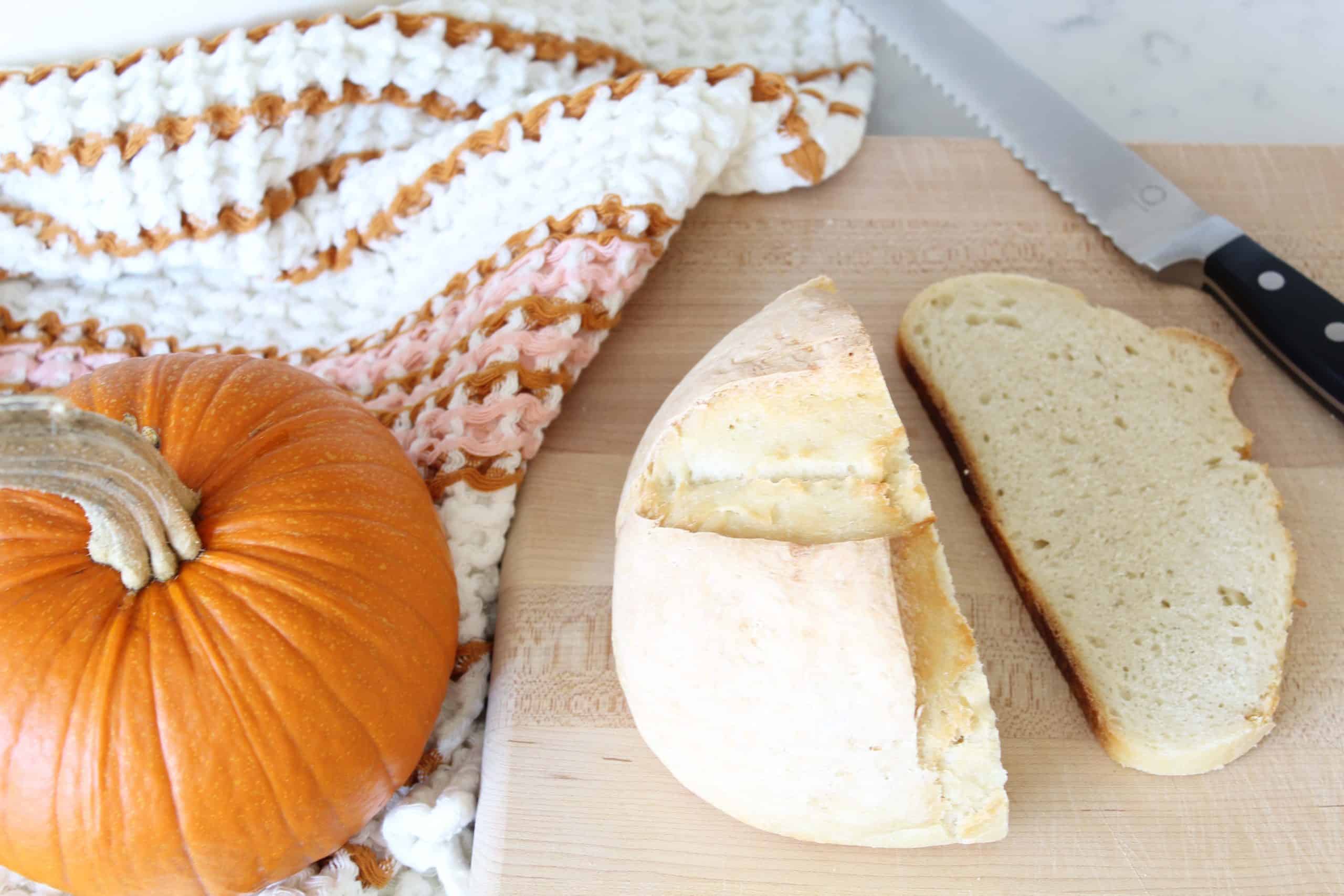 sourdough bread on bread board with pumpkin and anthropologie dish towel 