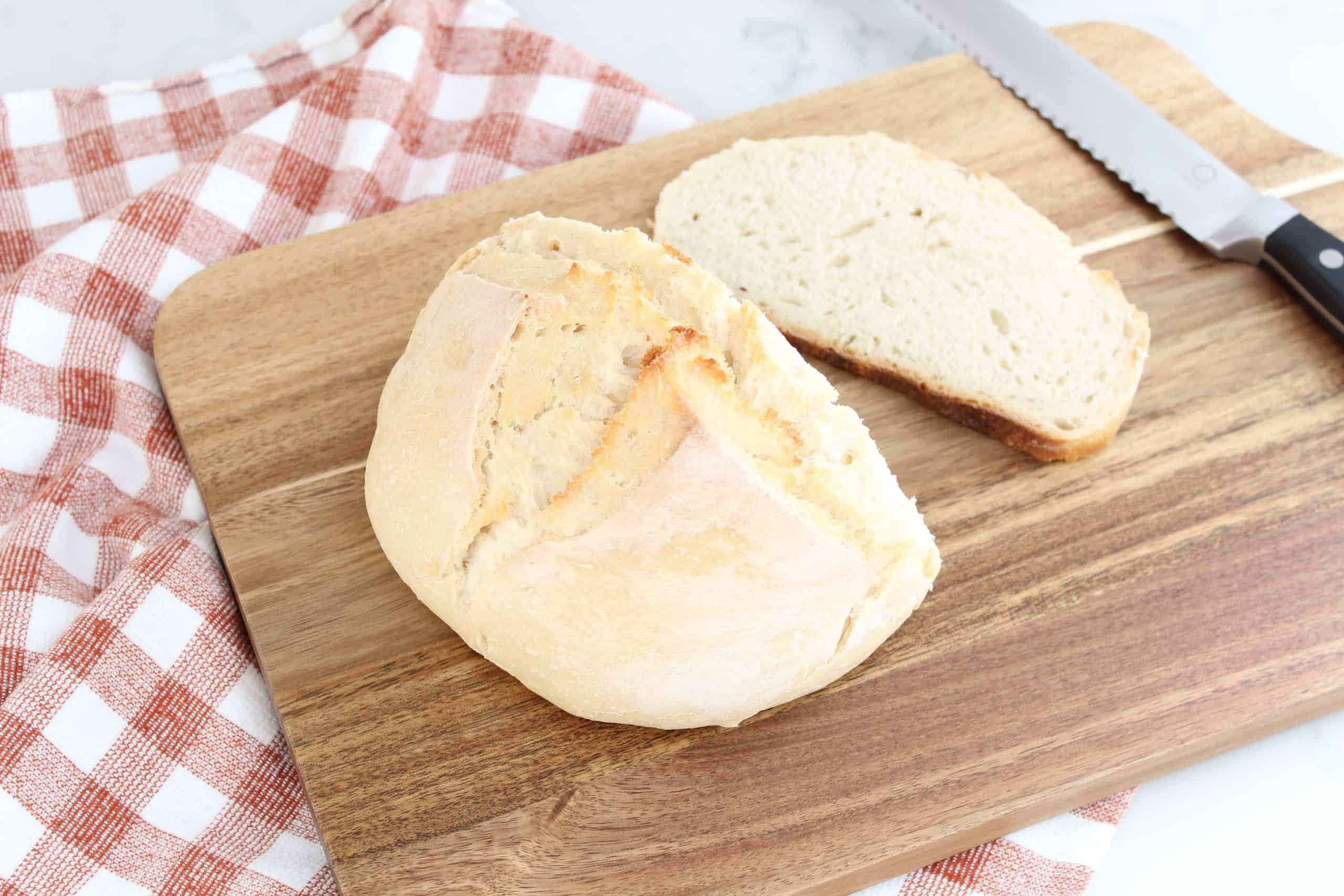 sourdough bread on a threshold bread boards with an orange gingham towel 