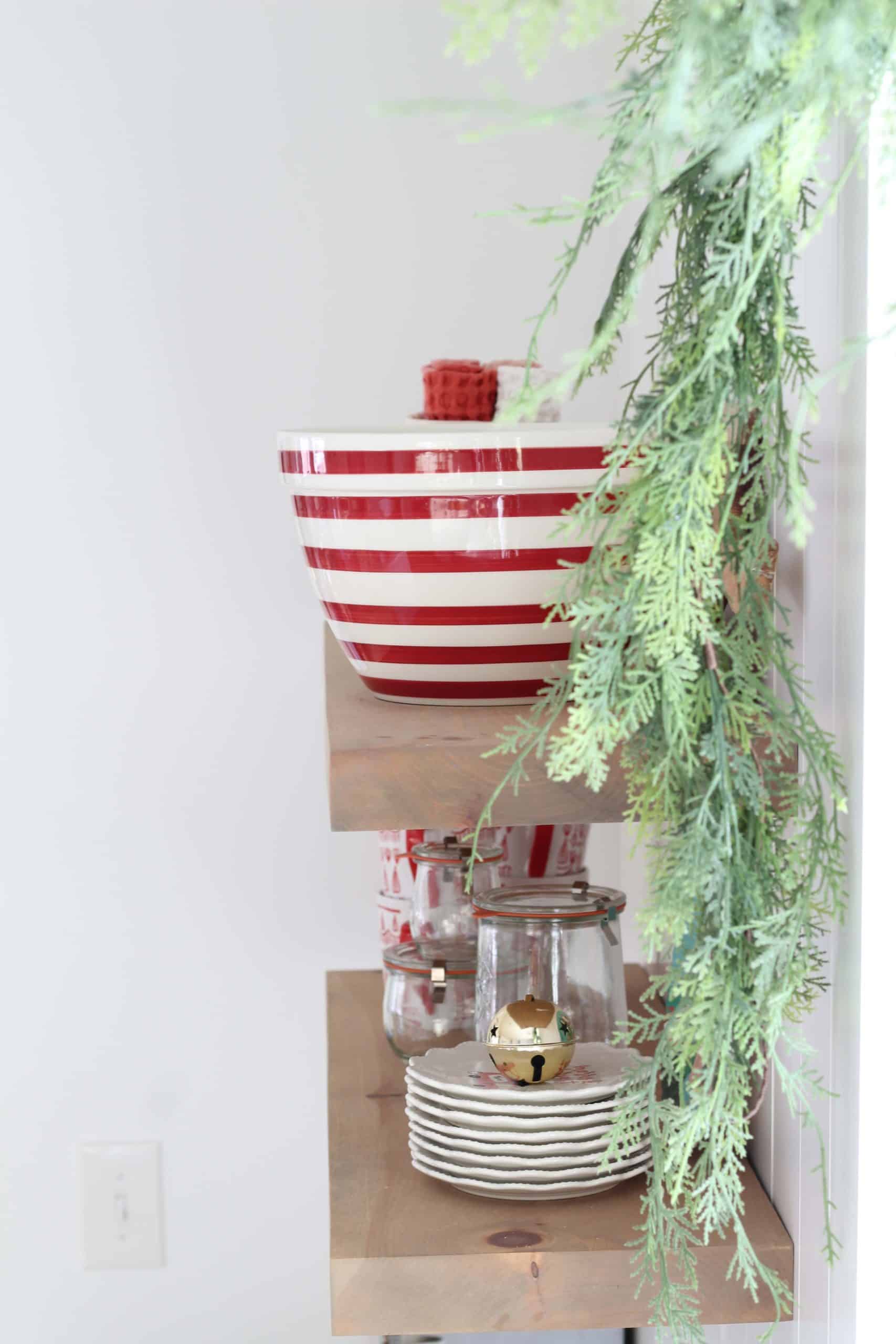 christmas garland around window, crate and barrel red striped bowl, open kitchen shelves