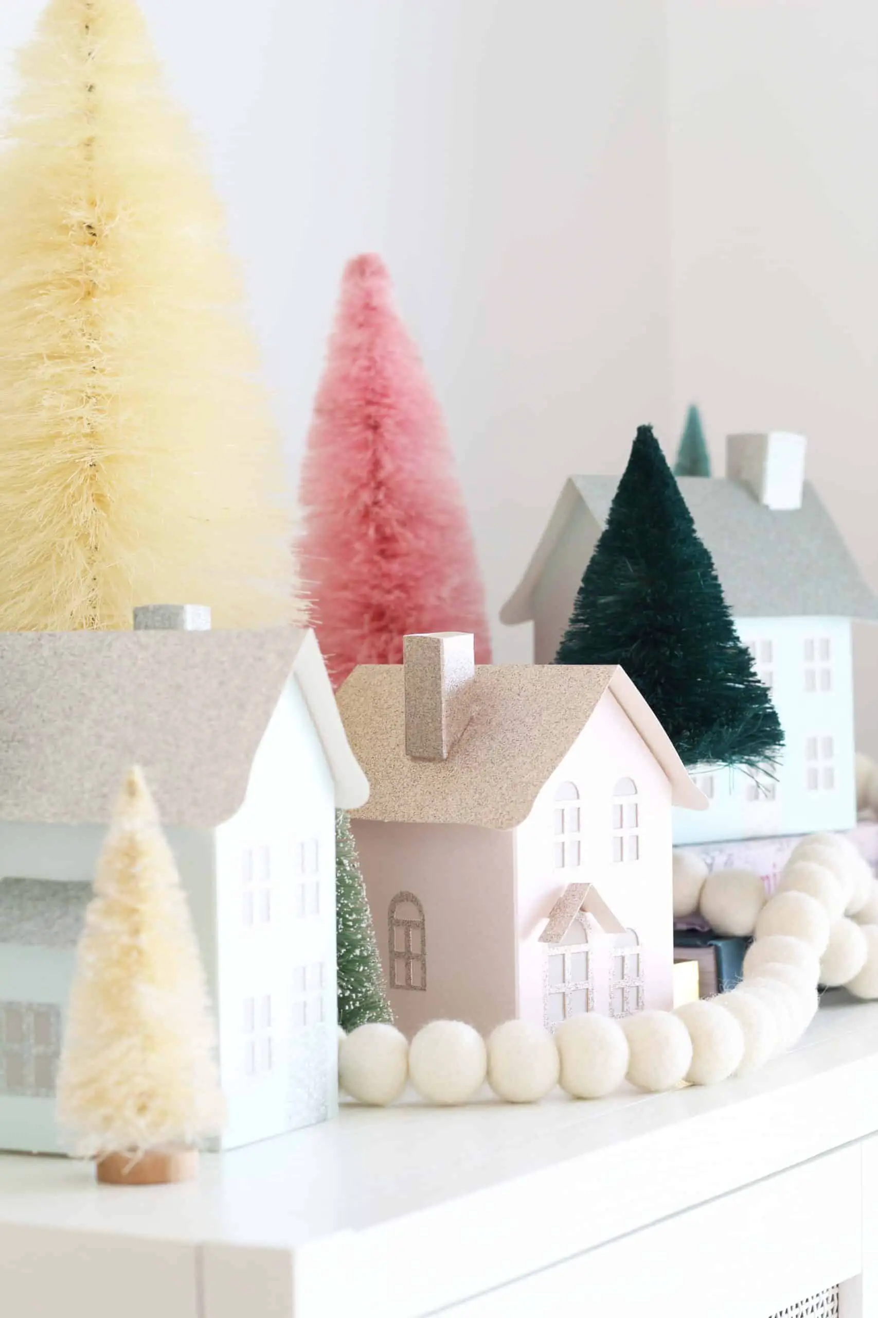 paper putz houses in pastel colors with colorful bottle brush trees